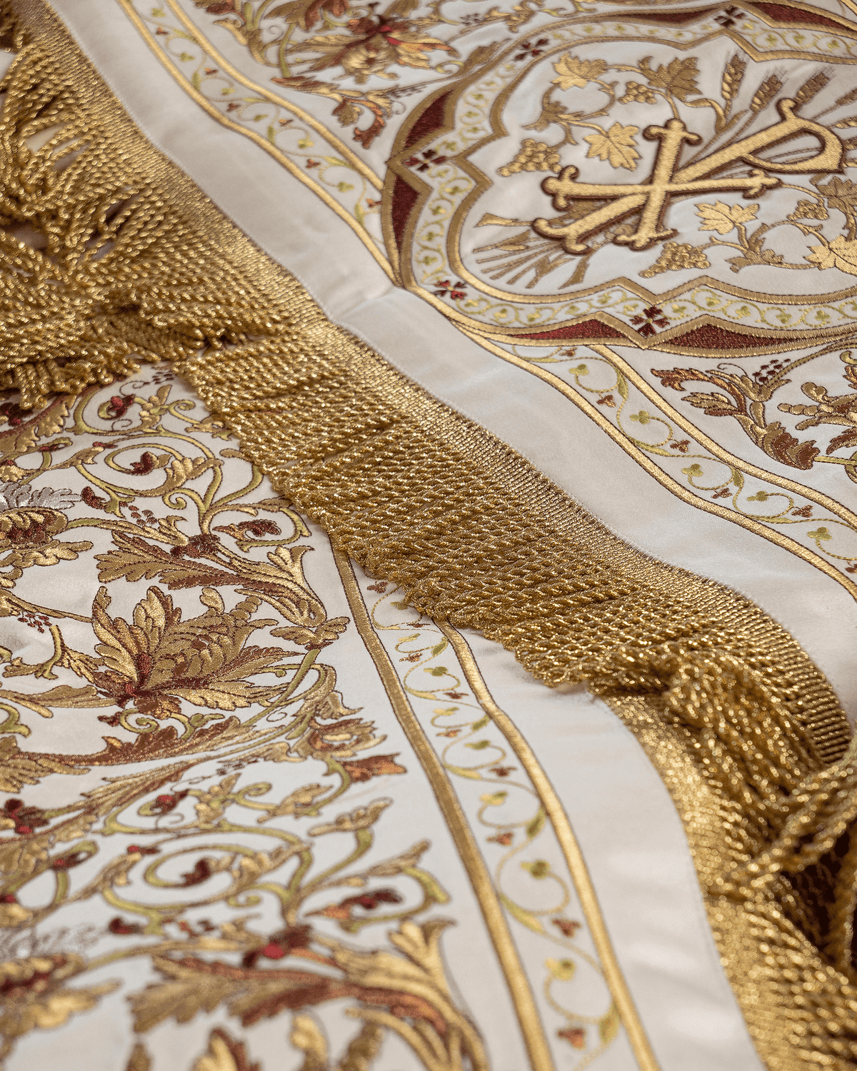 Processional canopy detail showing gold satin fringe and embroidered floral motifs