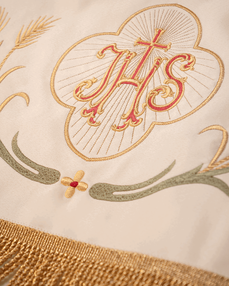 Corpus Christi canopy close-up showing embroidered gold IHS medallion and green scrollwork