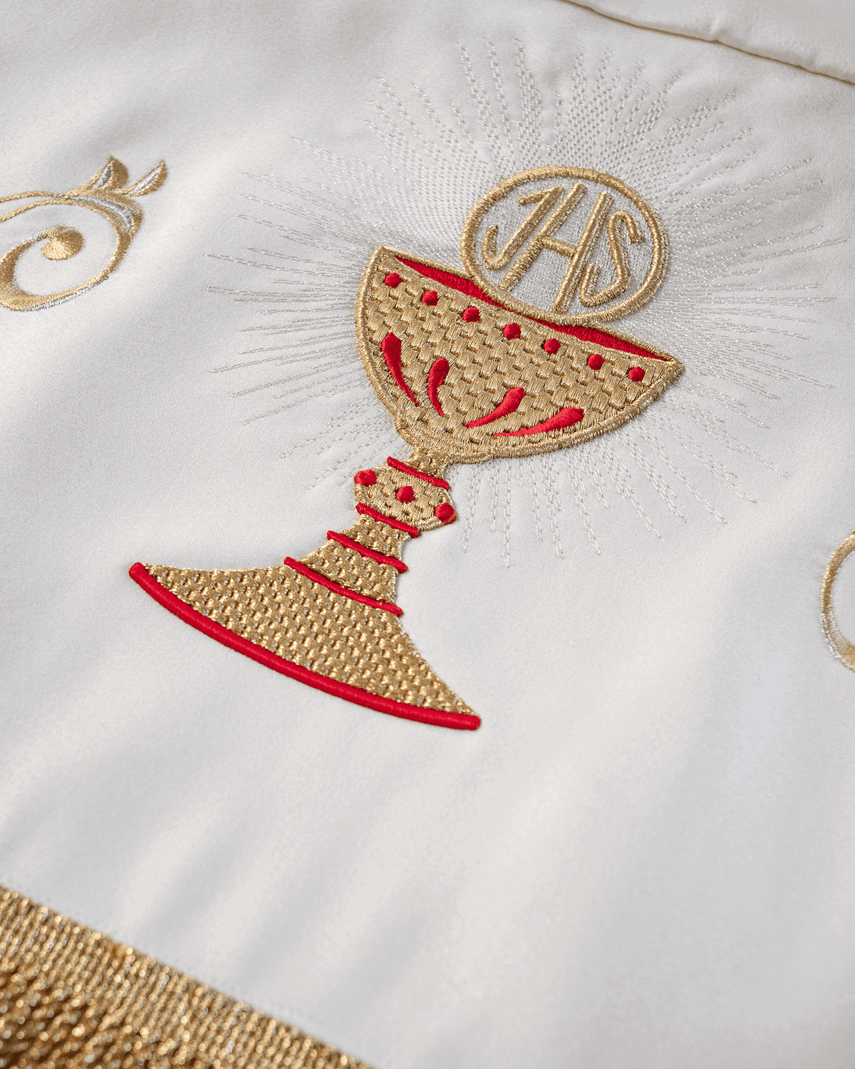 Processional canopy close-up with embroidered gold and red communion chalice motif