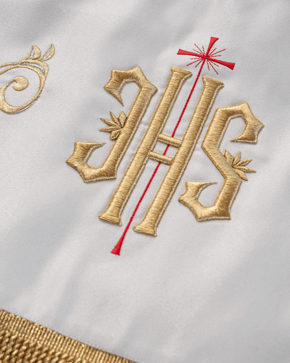 Processional canopy close-up showing embroidered gold IHS with red cross