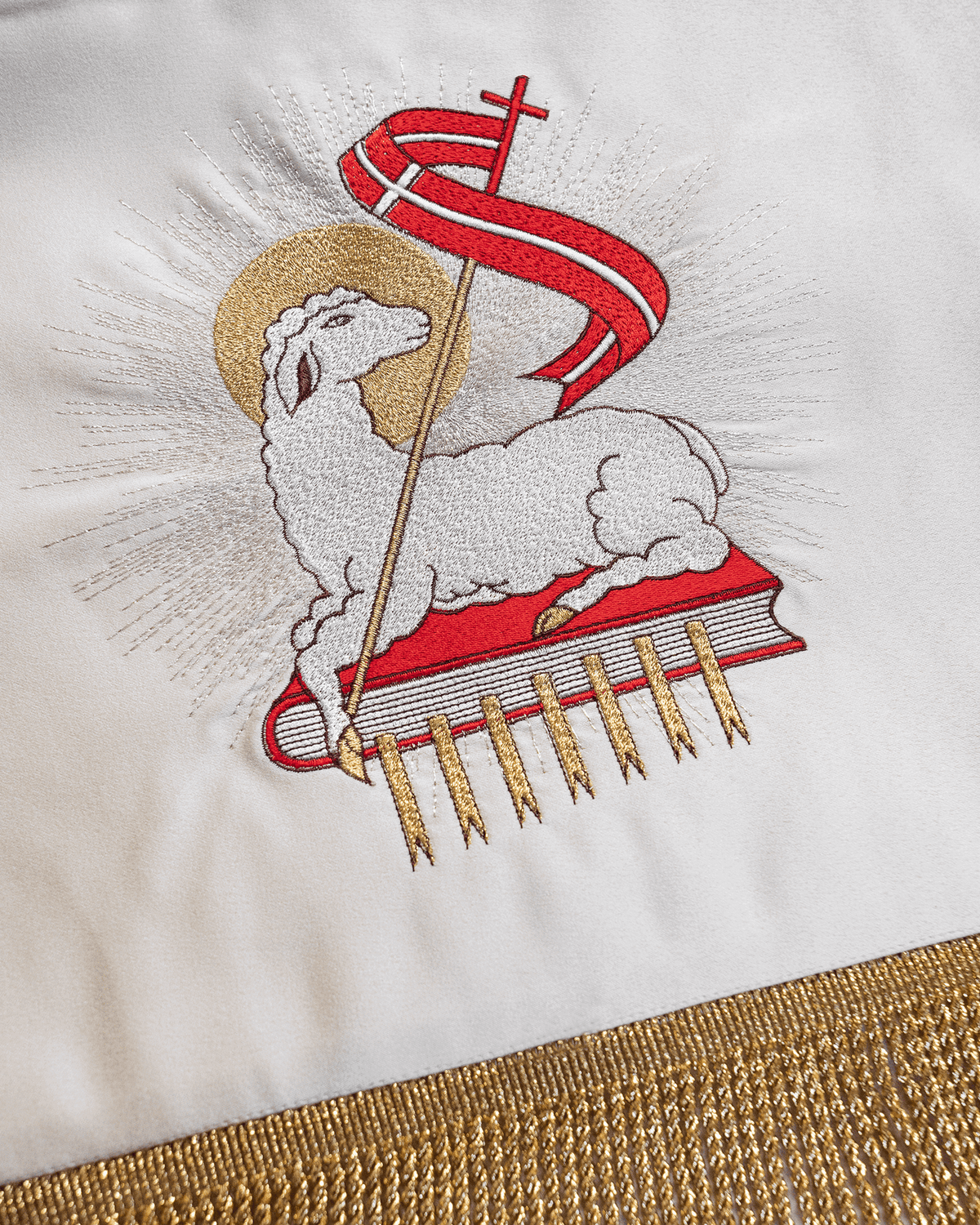 Processional canopy close-up showing embroidered Agnus Dei motif in red, white and gold