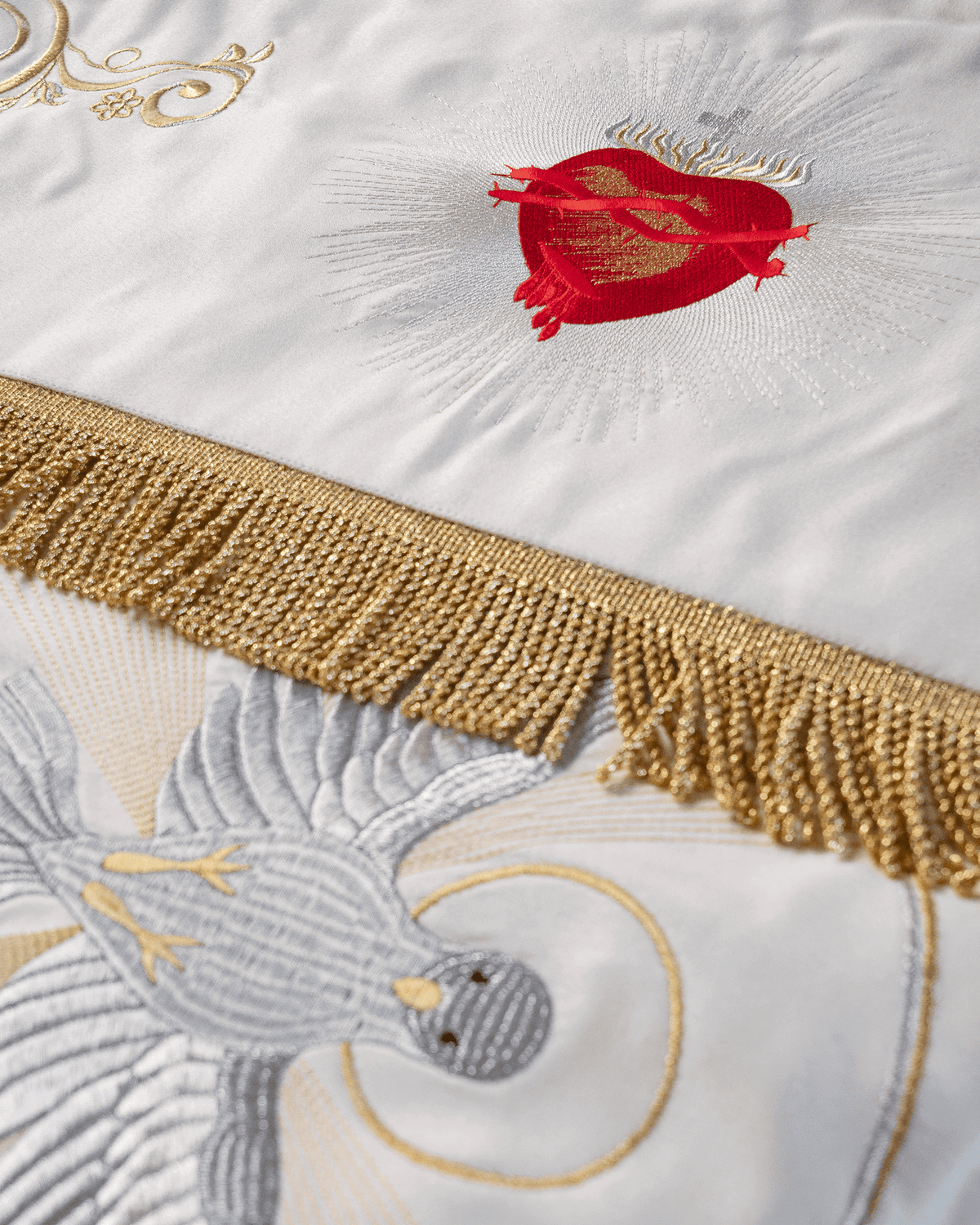 Processional canopy detail with embroidered Sacred Heart of Jesus and gold fringe