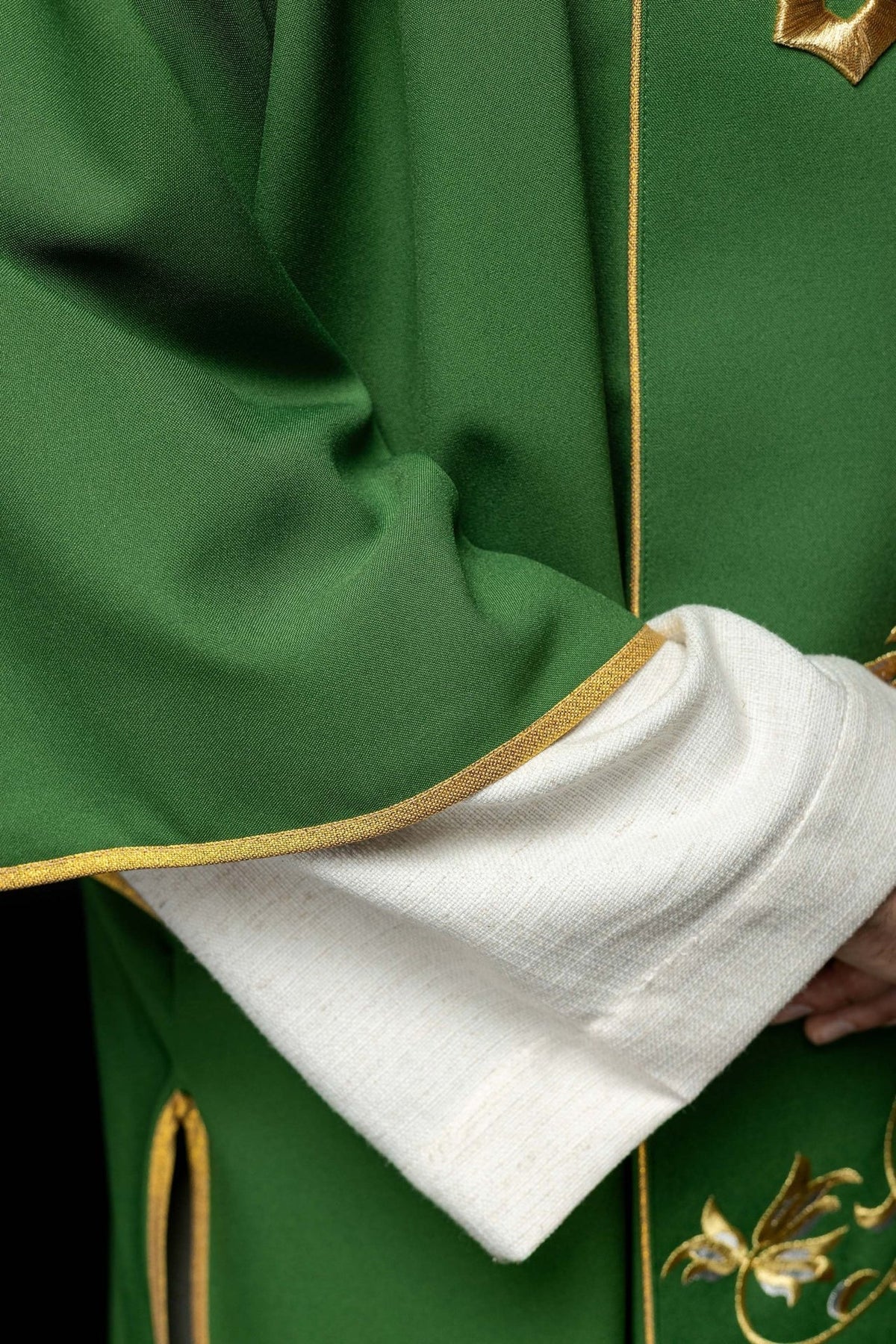 Green dalmatic close-up showing fabric, gold trim and sleeve edge
