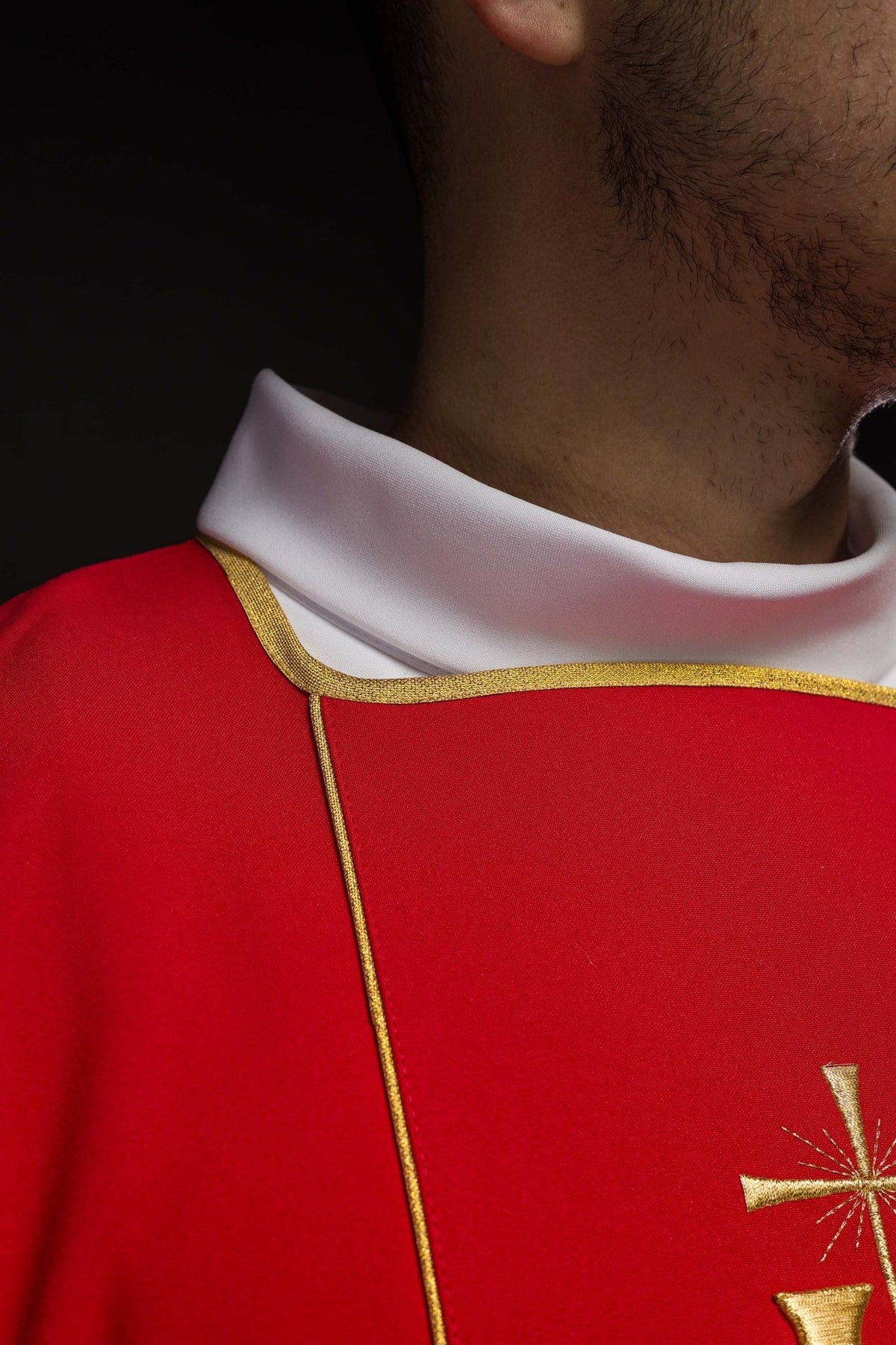 Red dalmatic sleeve detail with gold trim and white cuff