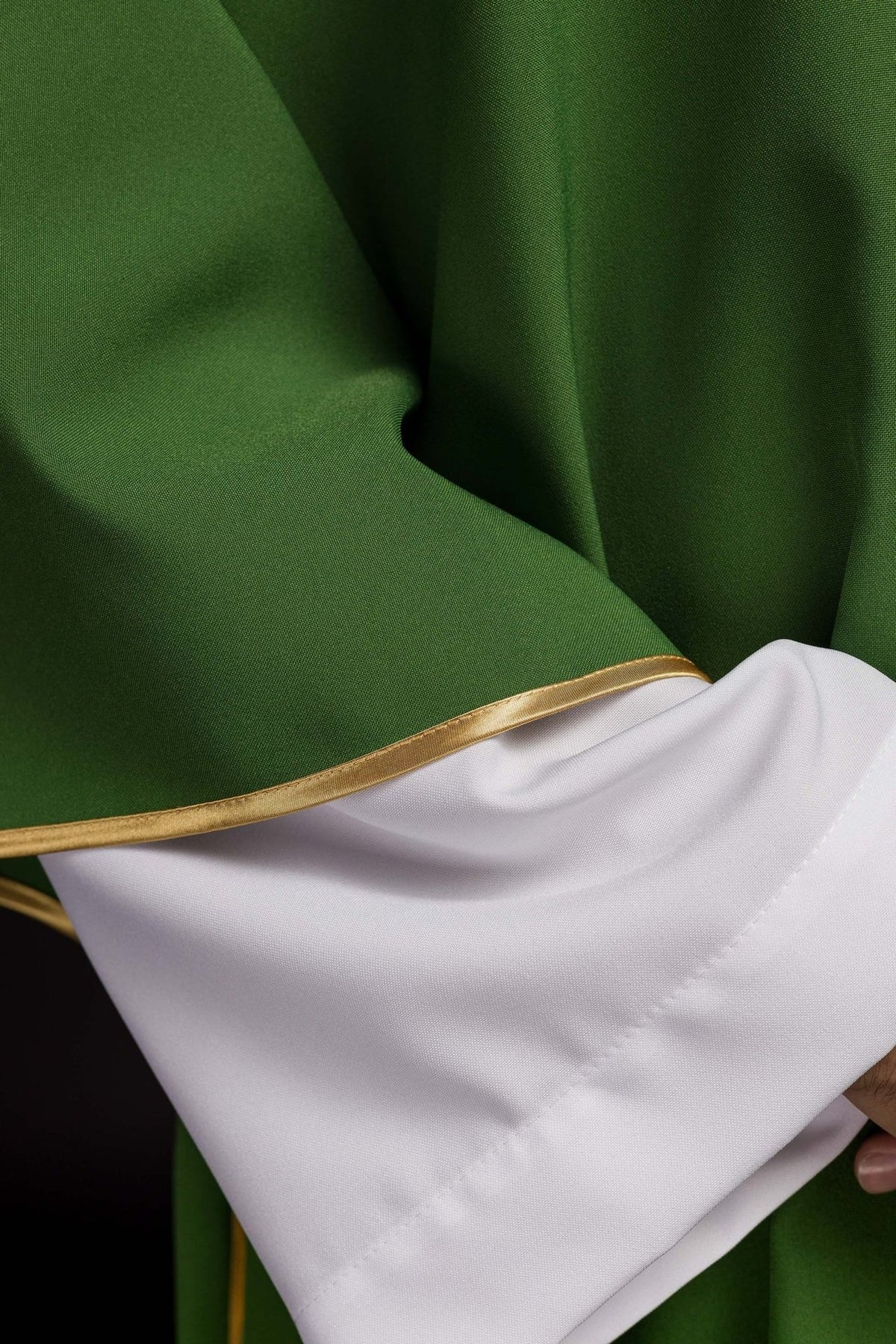Green dalmatic close-up showing polyester fabric and gold trim
