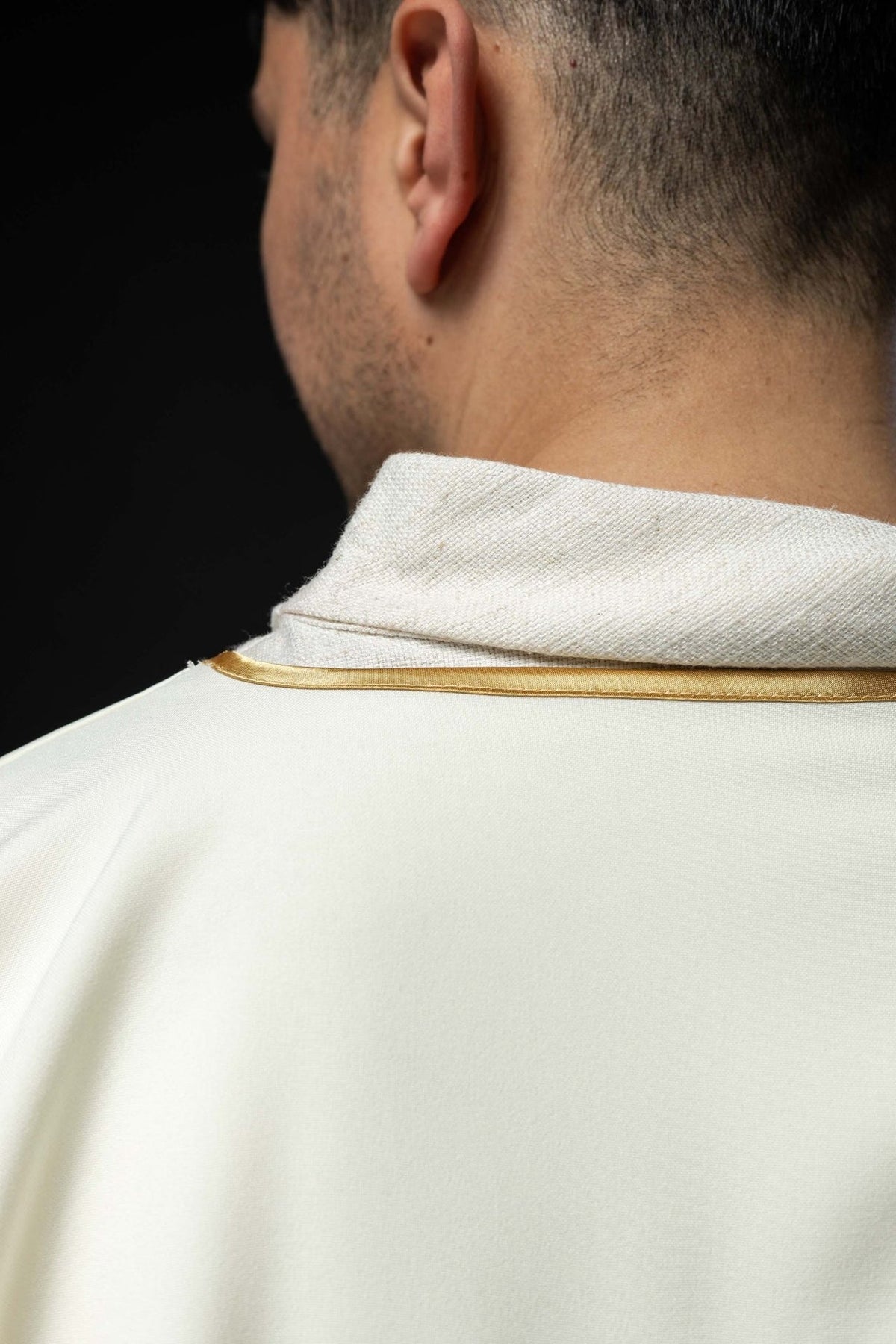 Ecru dalmatic sleeve close-up with gold trim and textured cuff