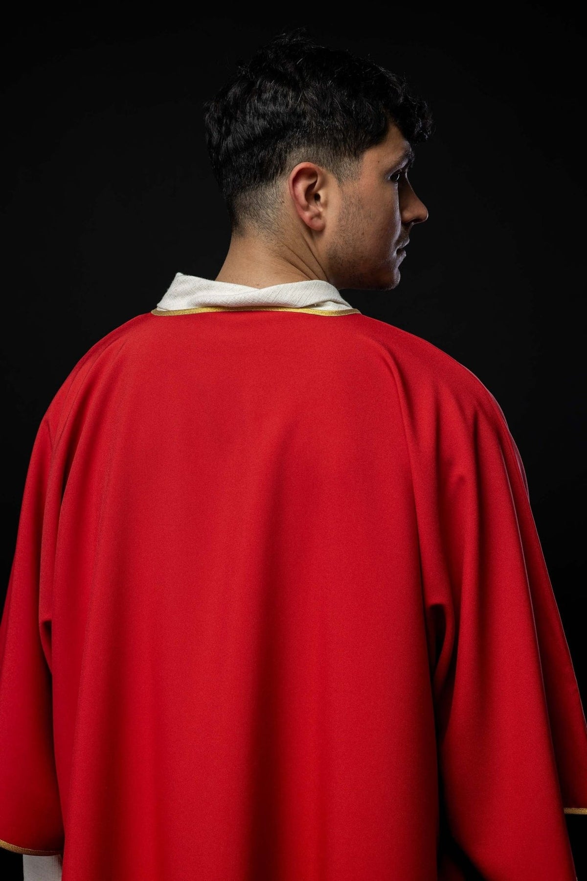 Red dalmatic sleeve close-up with gold trim and white cuff