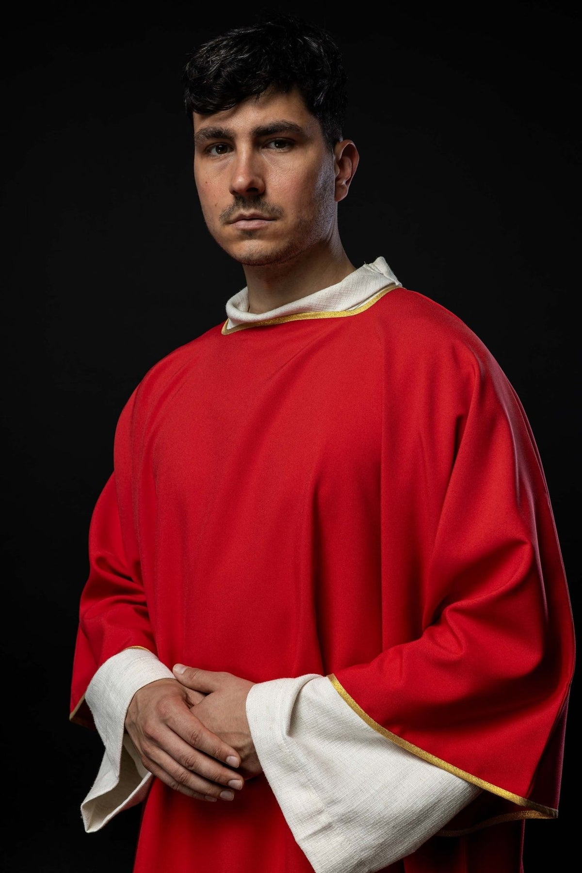 Red dalmatic front three-quarter view with white cuffs and gold trim