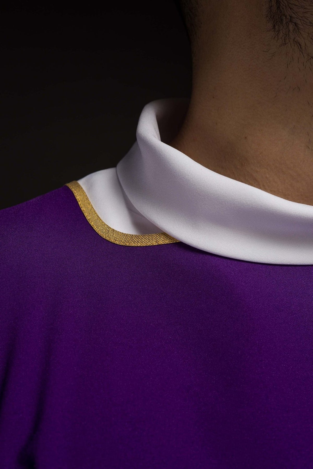 Purple dalmatic close-up showing white collar and gold trim