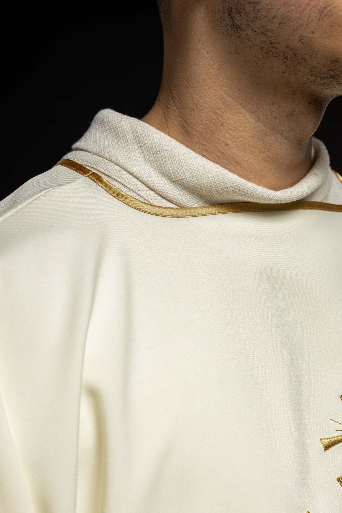 Ivory dalmatic front detail with gold IHS embroidery and wide sleeves