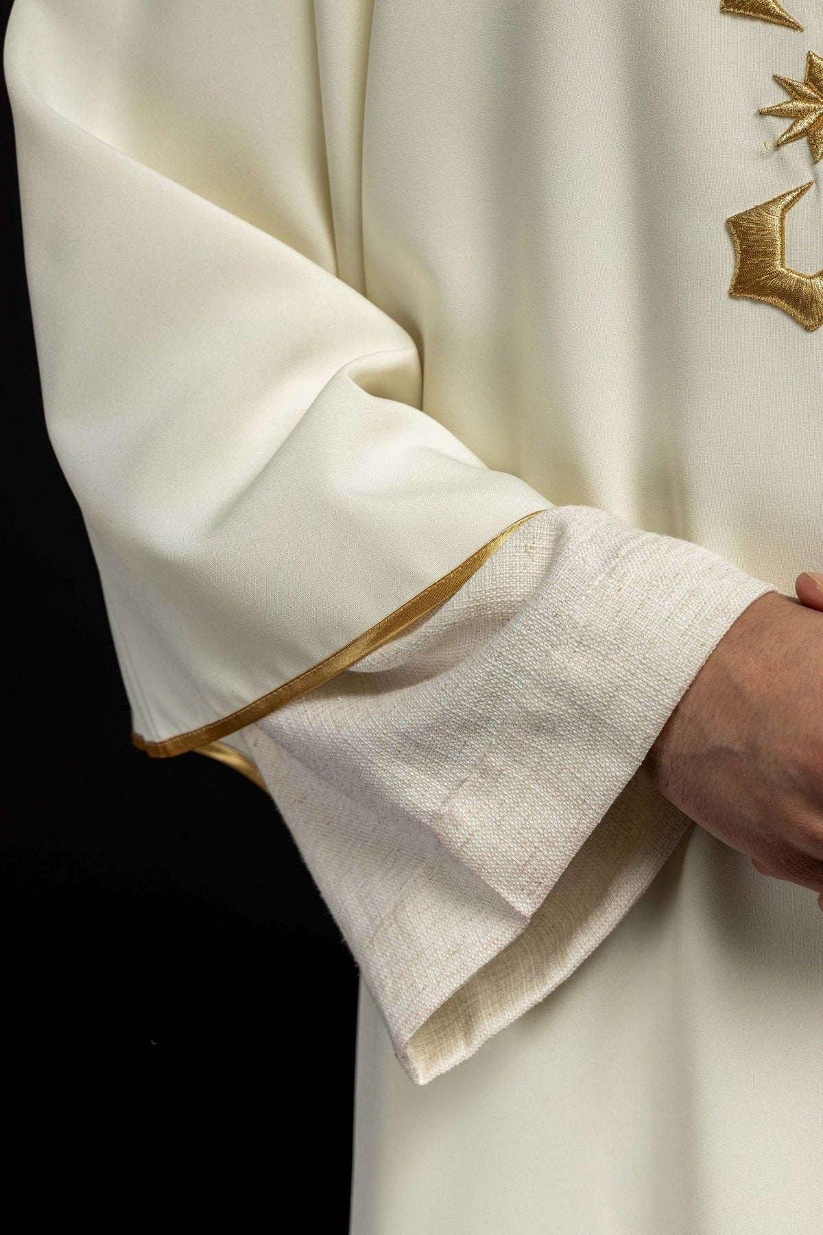 Dalmatic close-up showing ivory satin and gold-trimmed neckline