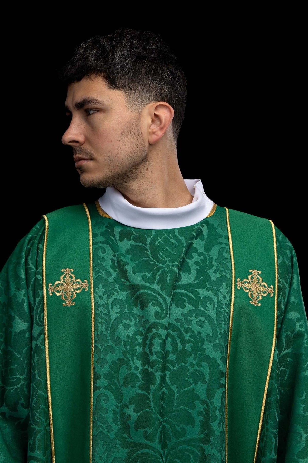 Green dalmatic close-up showing gold cross embroidery and patterned fabric