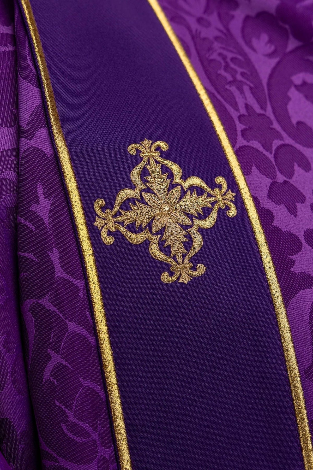 Purple dalmatic sleeve close-up with jacquard fabric and gold trim