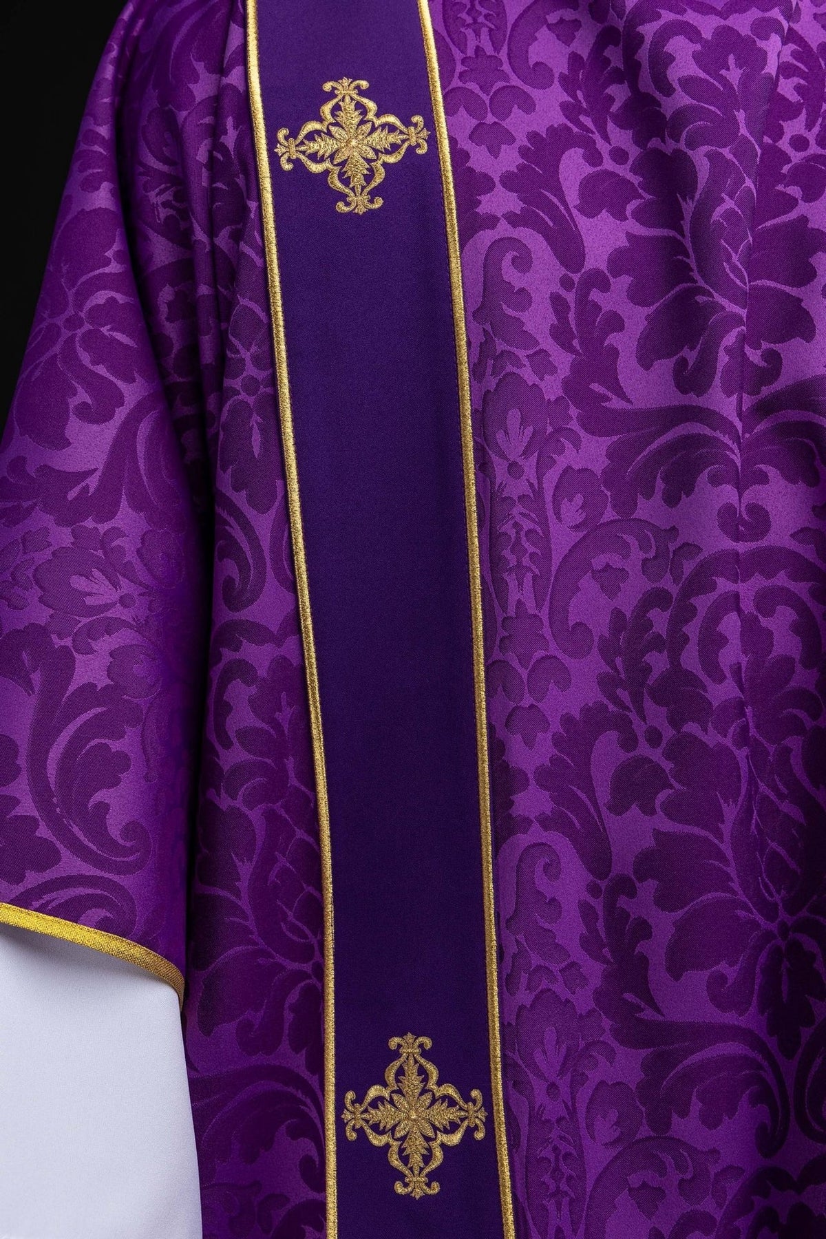 Purple dalmatic orphrey close-up with embroidered gold cross