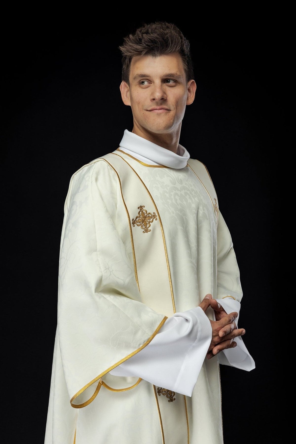 Ecru dalmatic side front view showing jacquard fabric and gold-trimmed orphreys