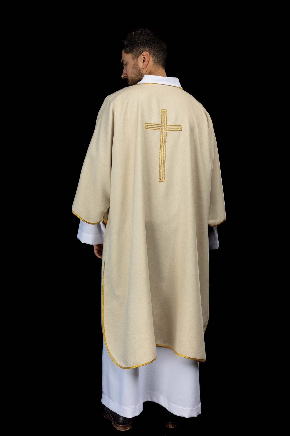 Ecru dalmatic worn from the back with gold trim