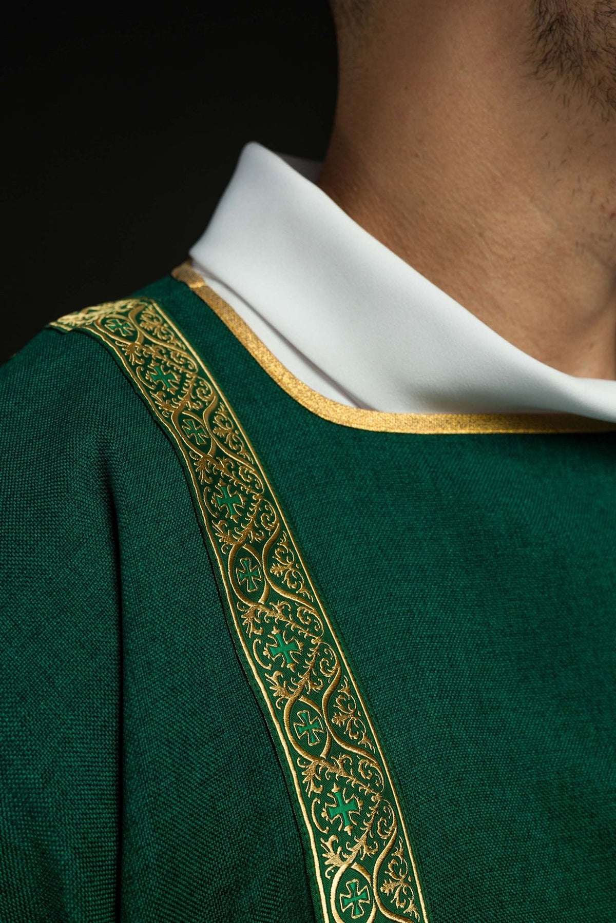 Green dalmatic close-up of white collar, gold trim and jacquard orphrey