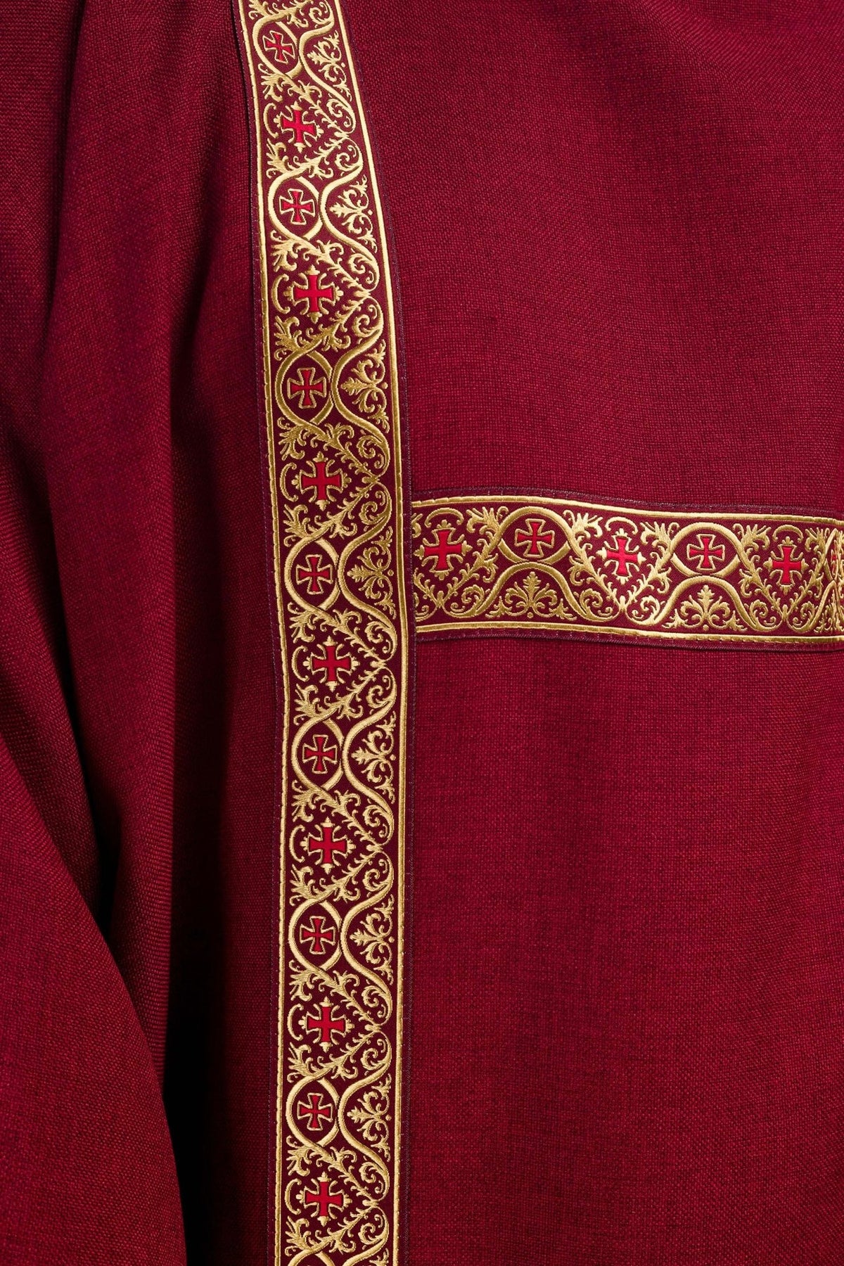 Red dalmatic close-up showing gold cross motifs on the orphrey