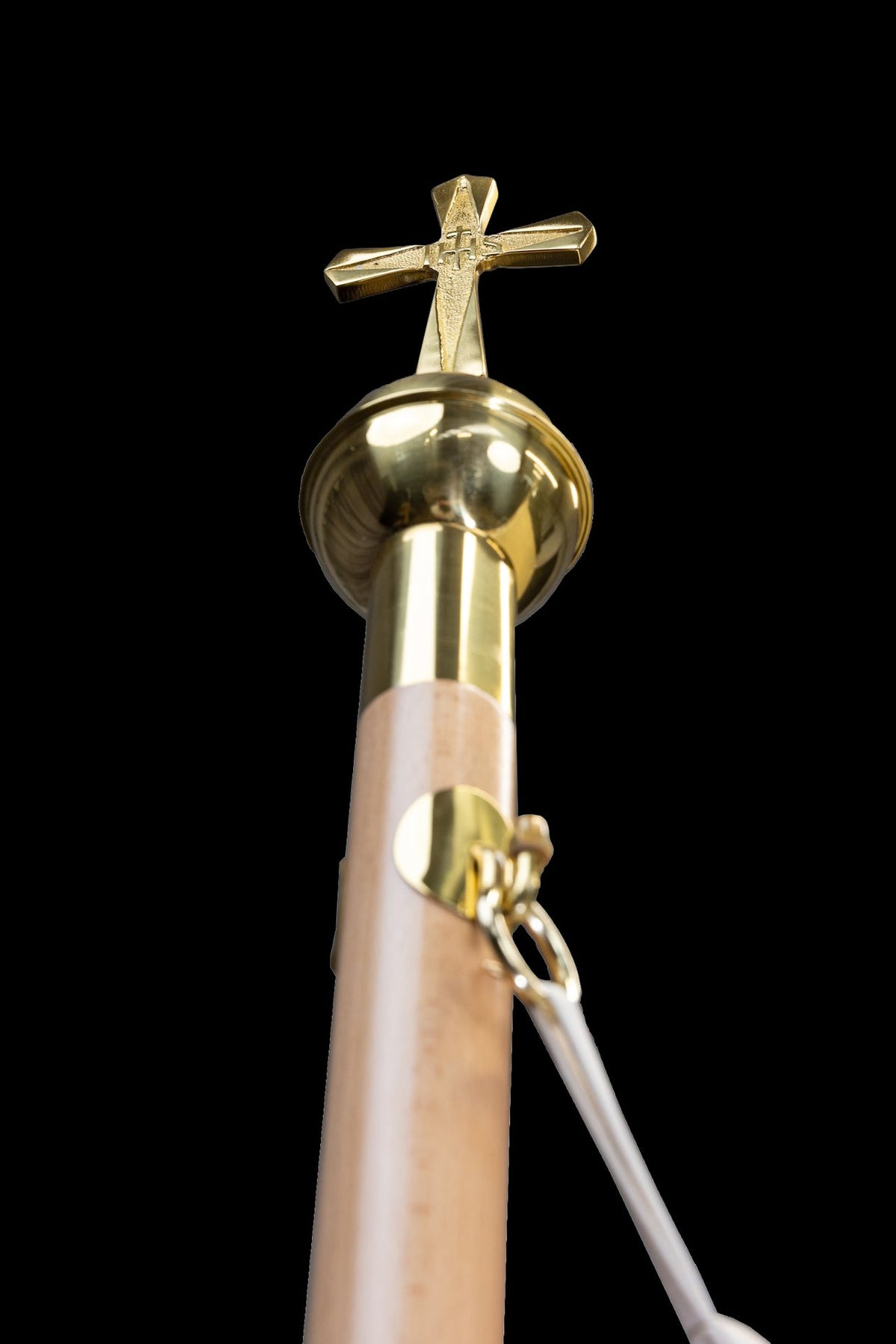 Canopy pole detail with gold finial, cross and fastening strap