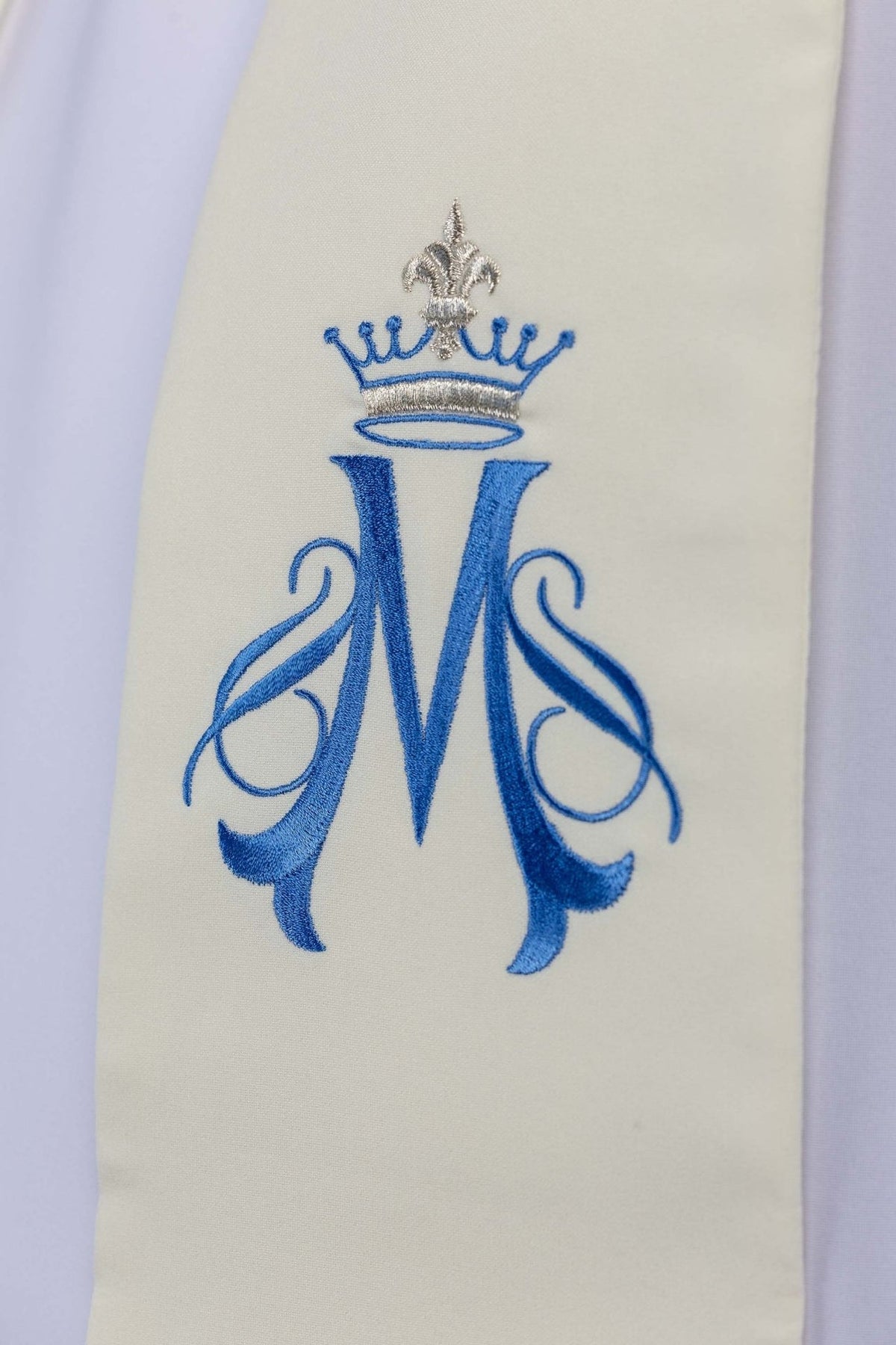 Ecru embroidered stole, close-up of blue Marian symbol with silver crown