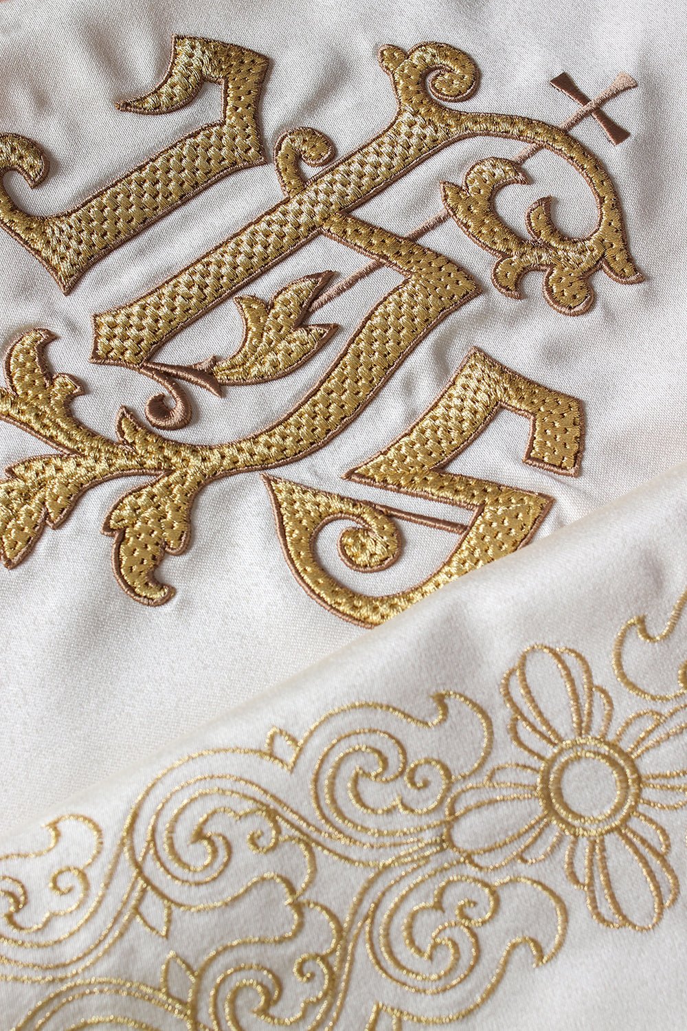 Liturgical veil close-up showing gold IHS embroidery on ivory fabric