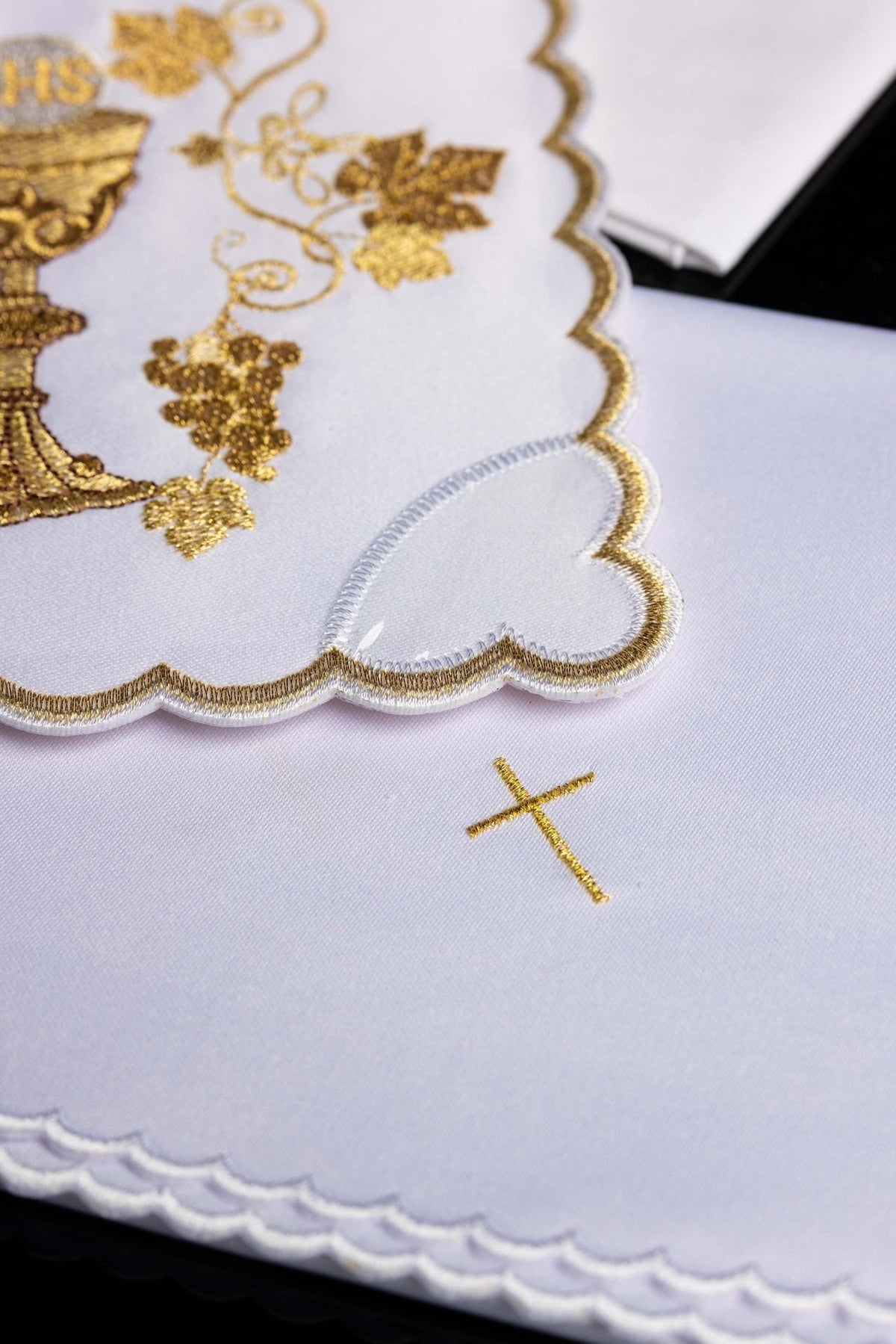 Altar linen set detail showing white fabric, gold cross embroidery and scalloped trim