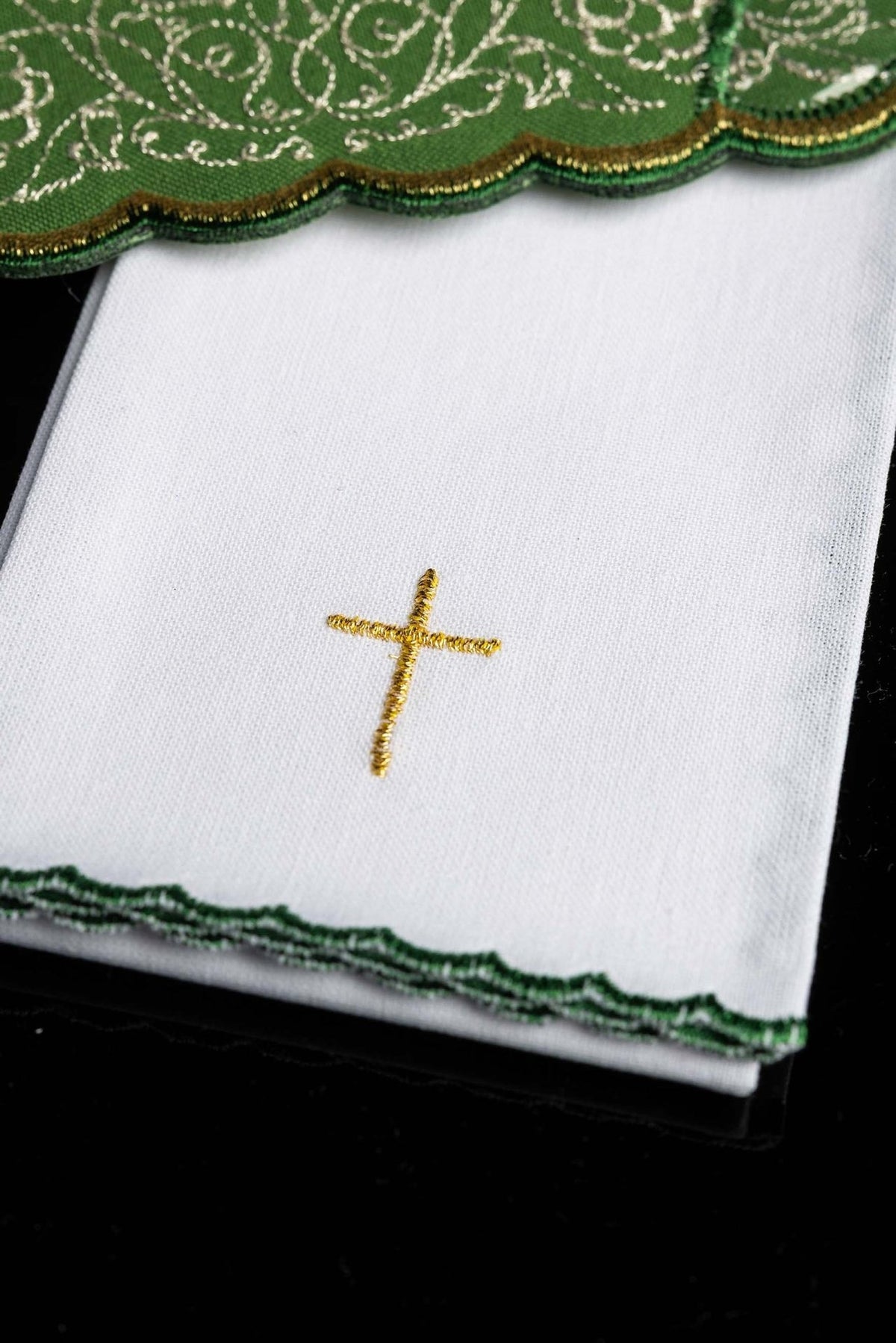 Altar linen set detail showing gold cross embroidery on white linen with green edging