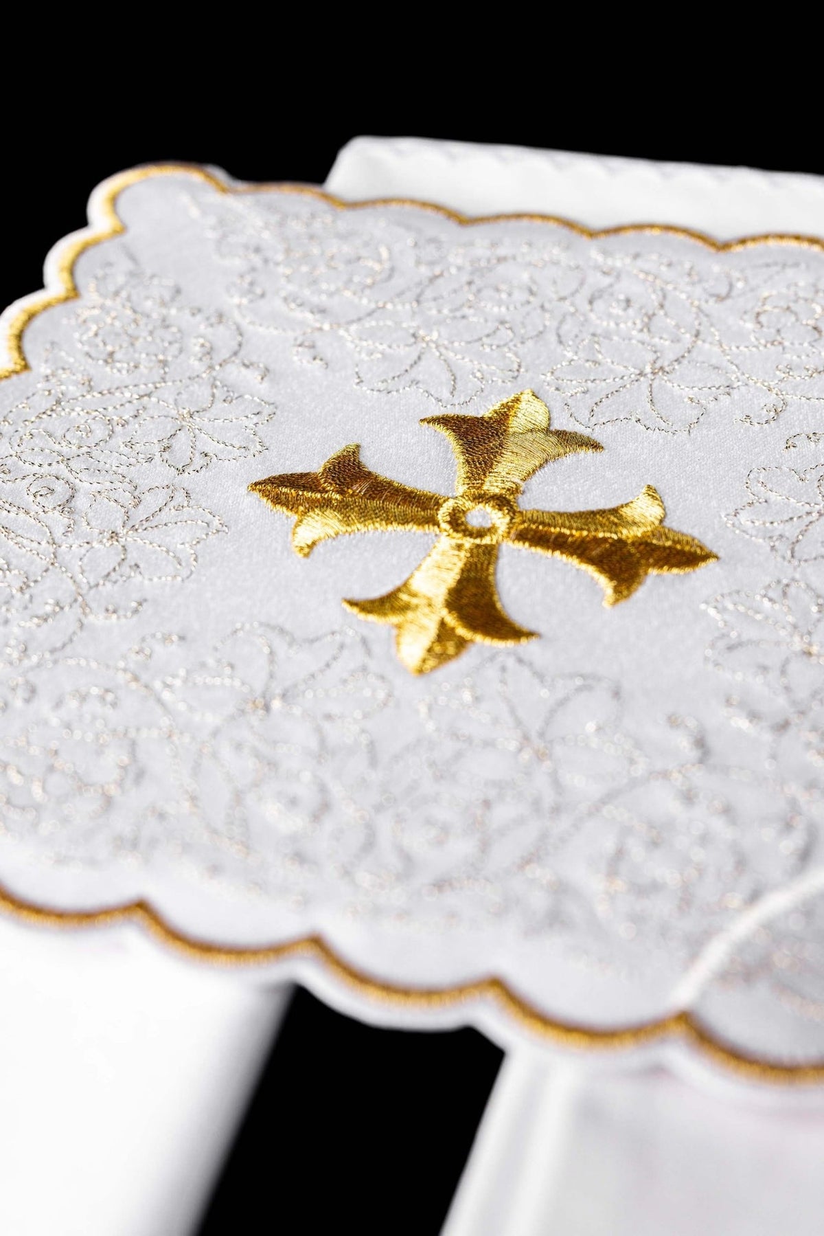 Altar linen set close-up showing gold embroidered cross on white fabric