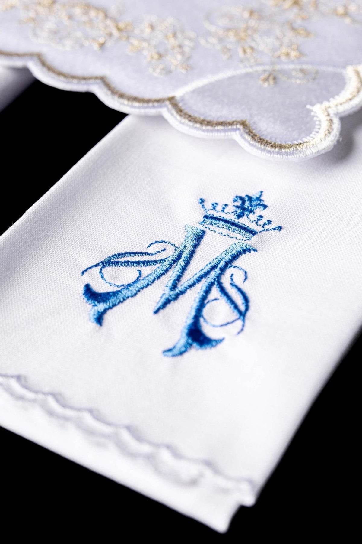 White altar linen set close-up showing blue Marian embroidery and scalloped edge