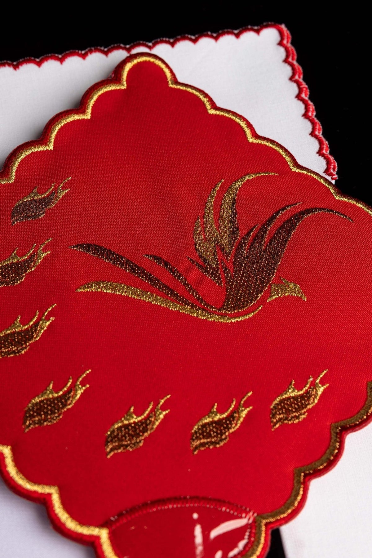 Altar linen set detail showing gold cross embroidery and red scalloped trim on white linen