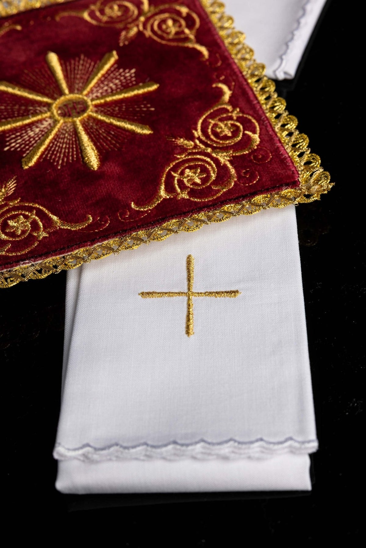 White altar linen with embroidered gold cross and scalloped edge