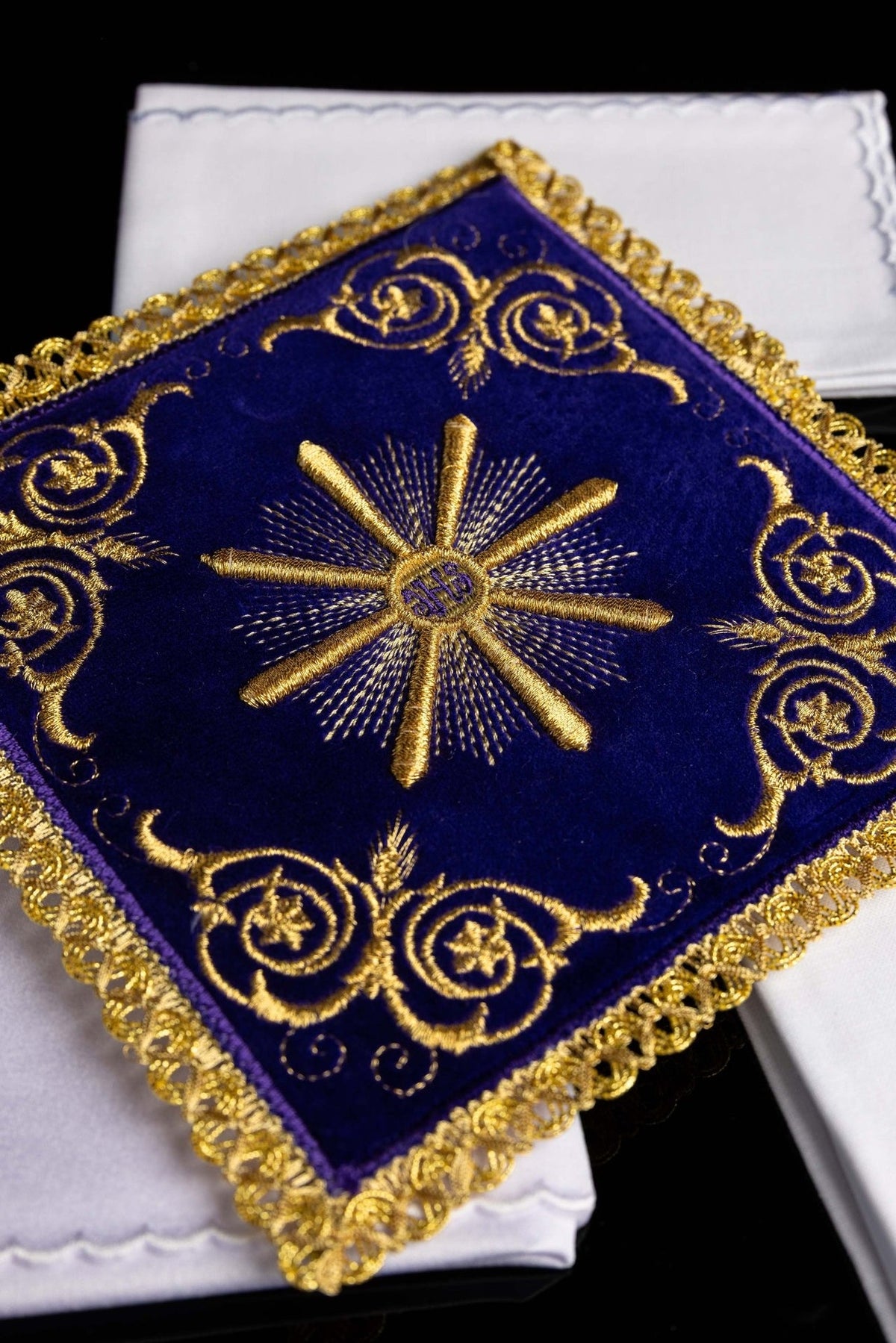 Purple velvet pall close-up with gold embroidery, ornate border and central IHS monogram