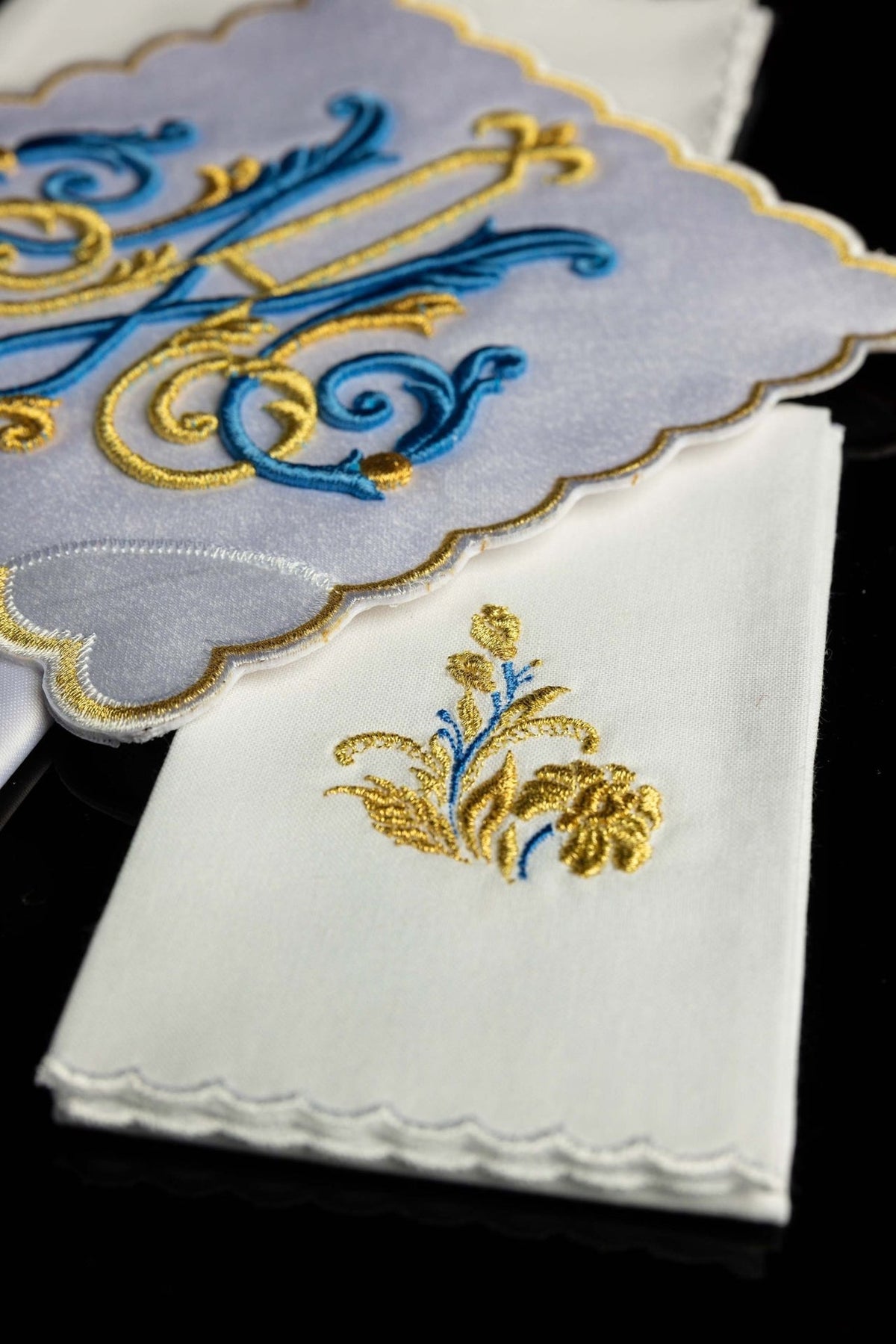 Altar linen set detail showing gold and blue floral embroidery and scalloped edge