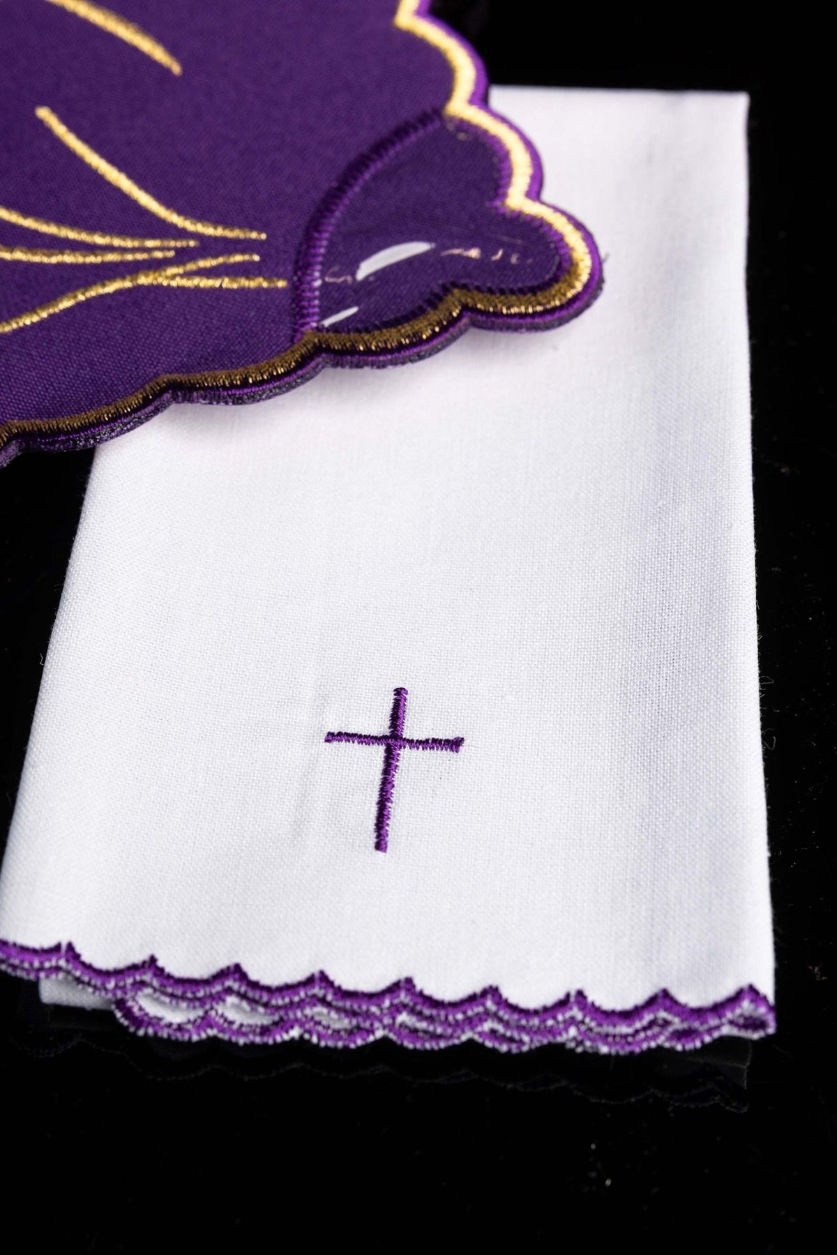 Altar linen set detail showing purple embroidered cross and layered scalloped edging