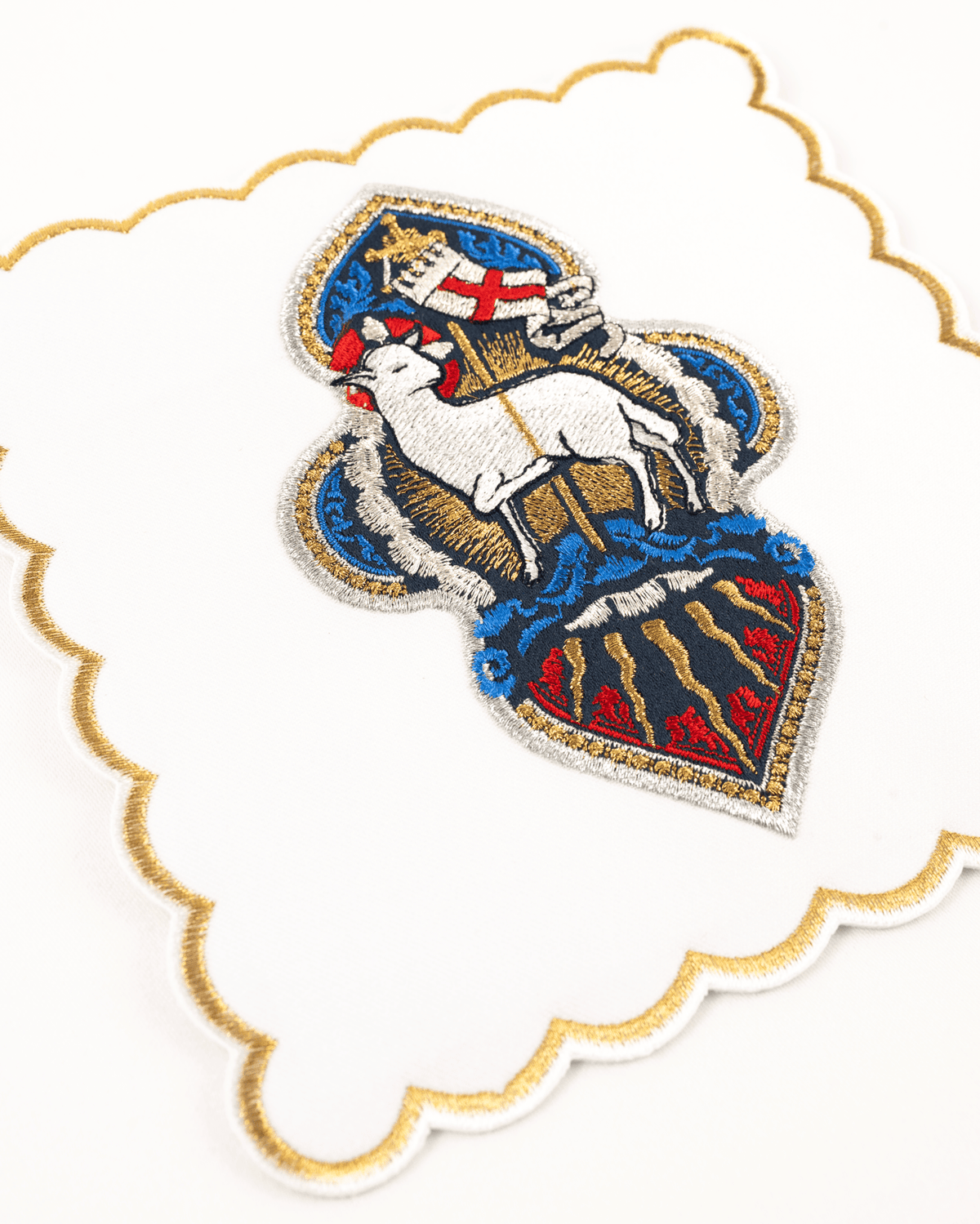Altar linen set close-up showing the embroidered Agnus Dei and gold scalloped edge
