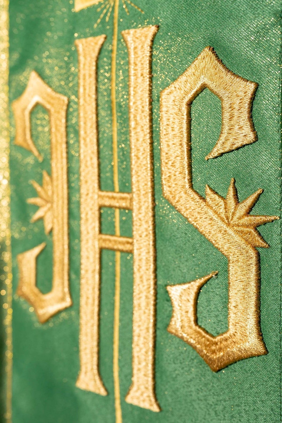 Green chasuble close-up of embroidered gold IHS on the orphrey