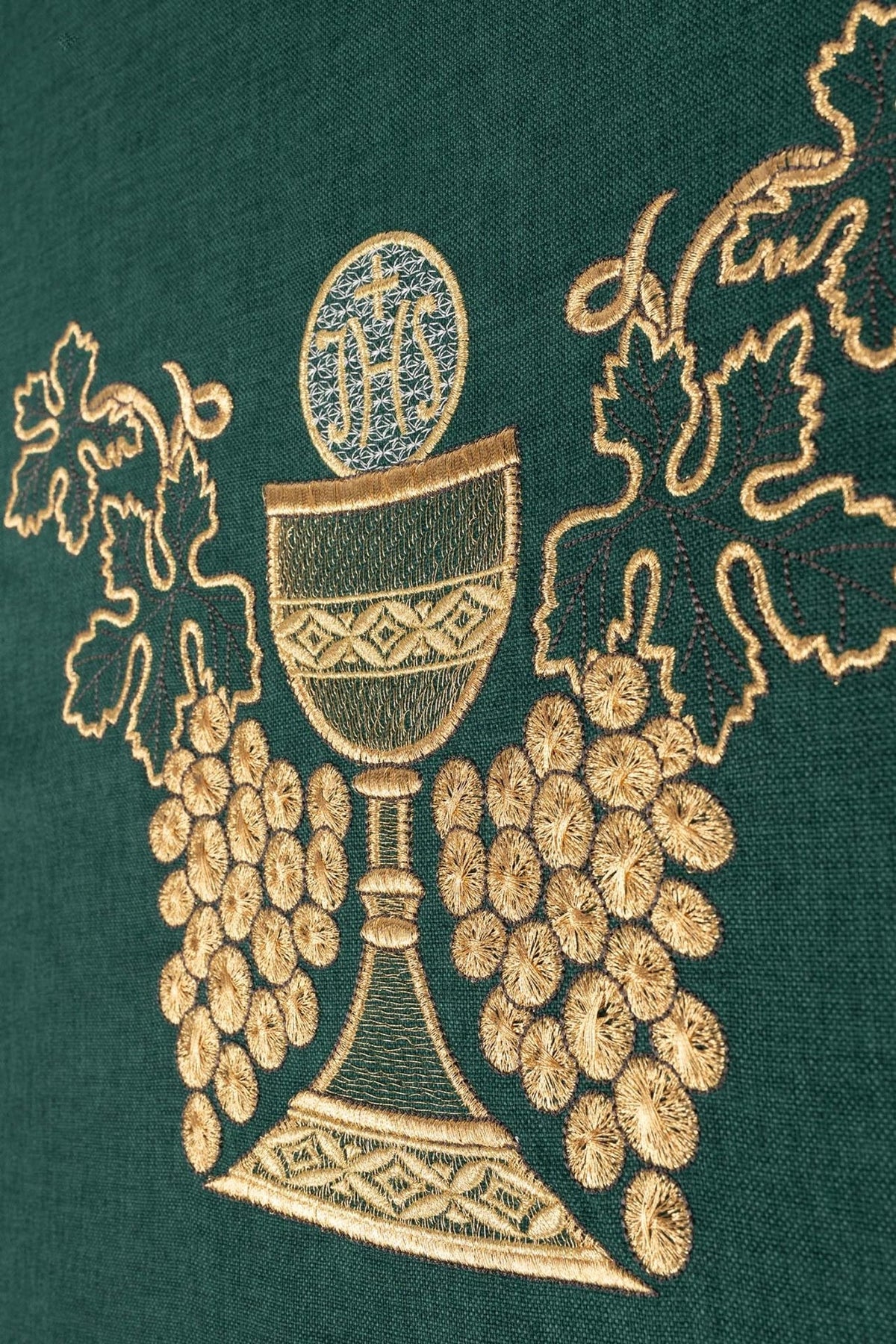 Green chasuble close-up showing embroidered gold chalice and grapes
