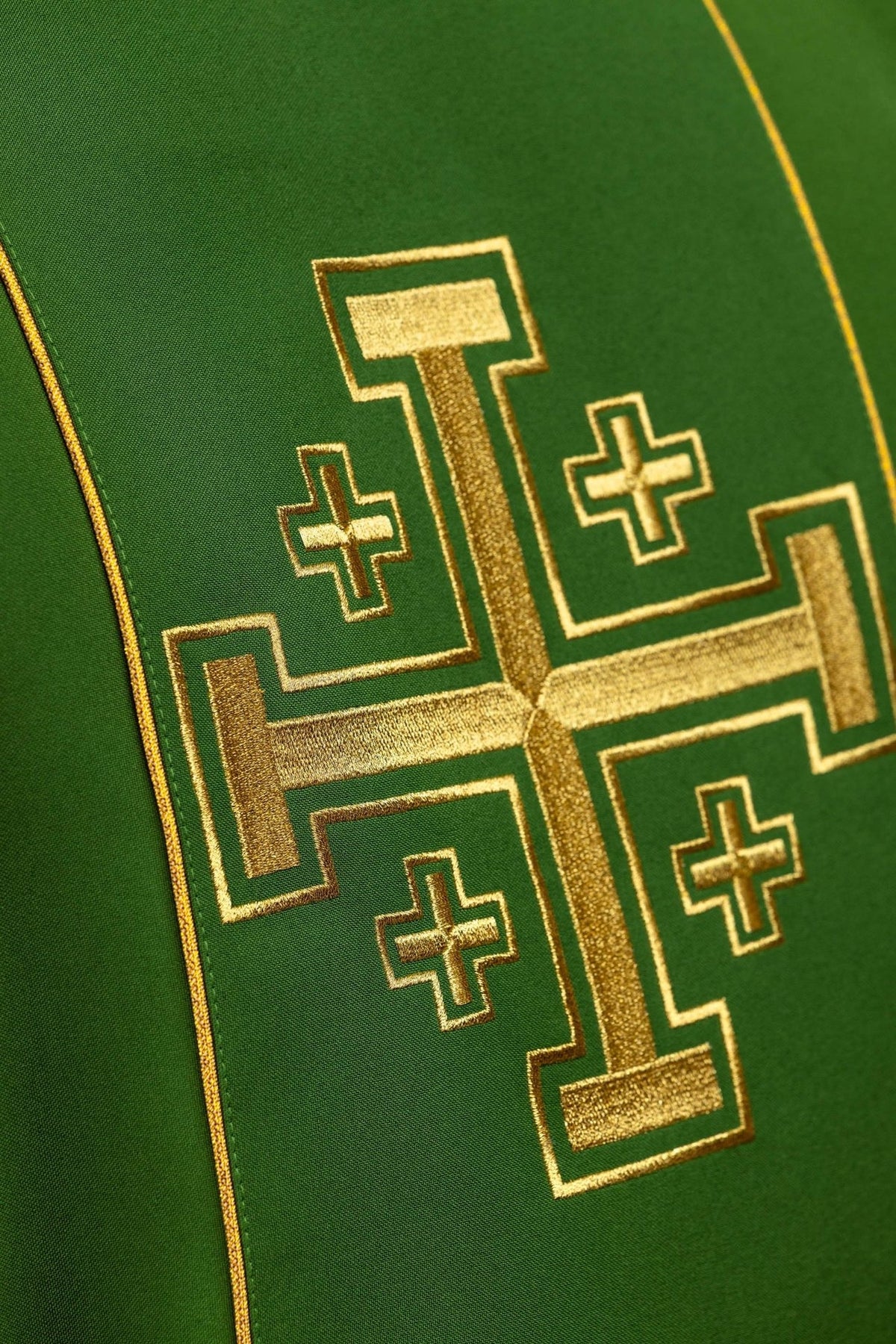 Green chasuble close-up showing embroidered gold Jerusalem cross and trim