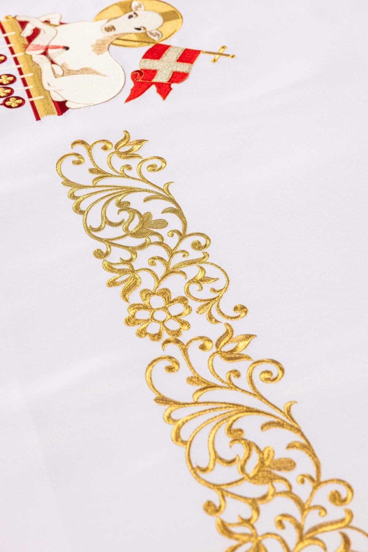 White altar cloth close-up showing a gold floral embroidery motif