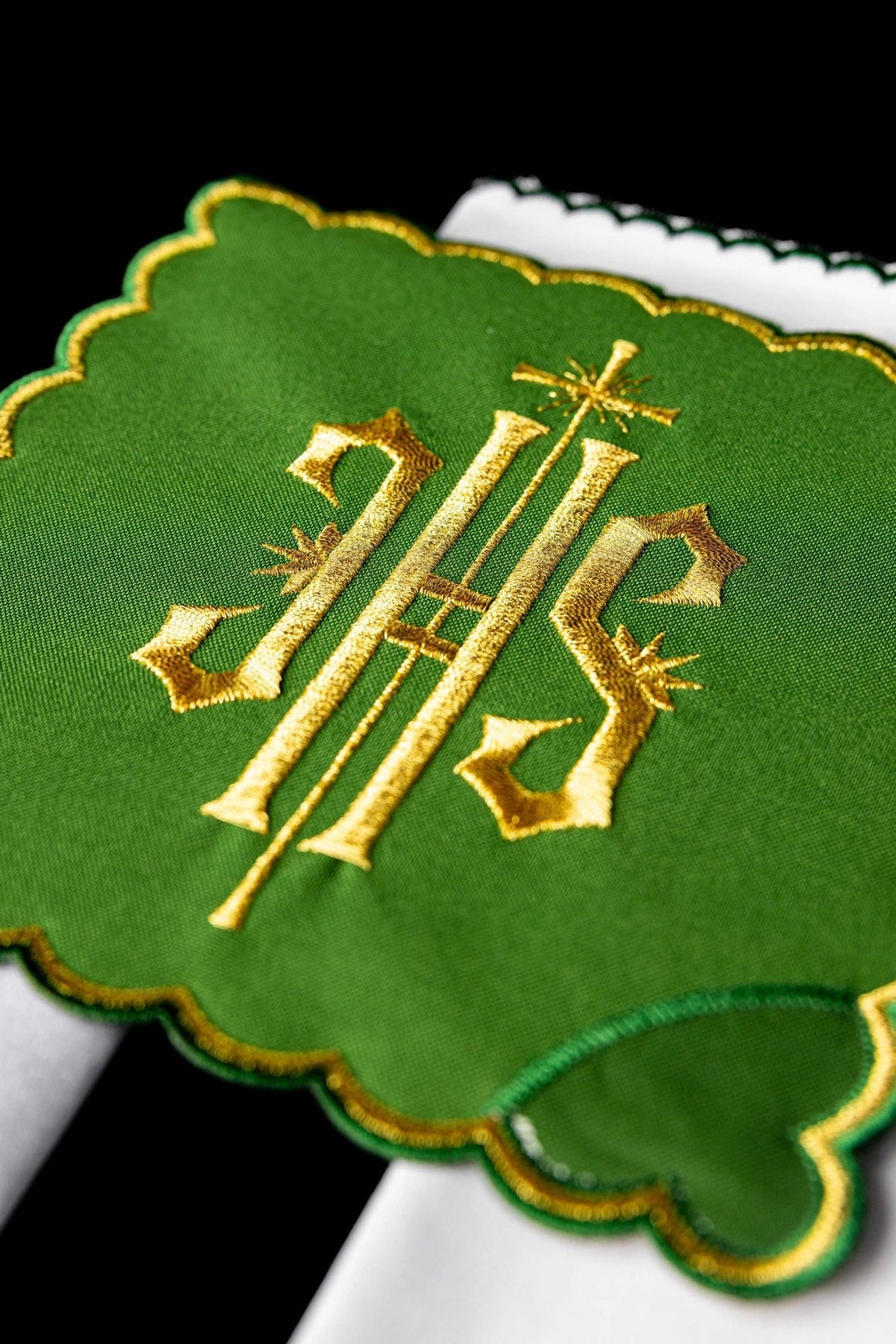 Altar linen set close-up showing green fabric, gold IHS embroidery and scalloped gold edging