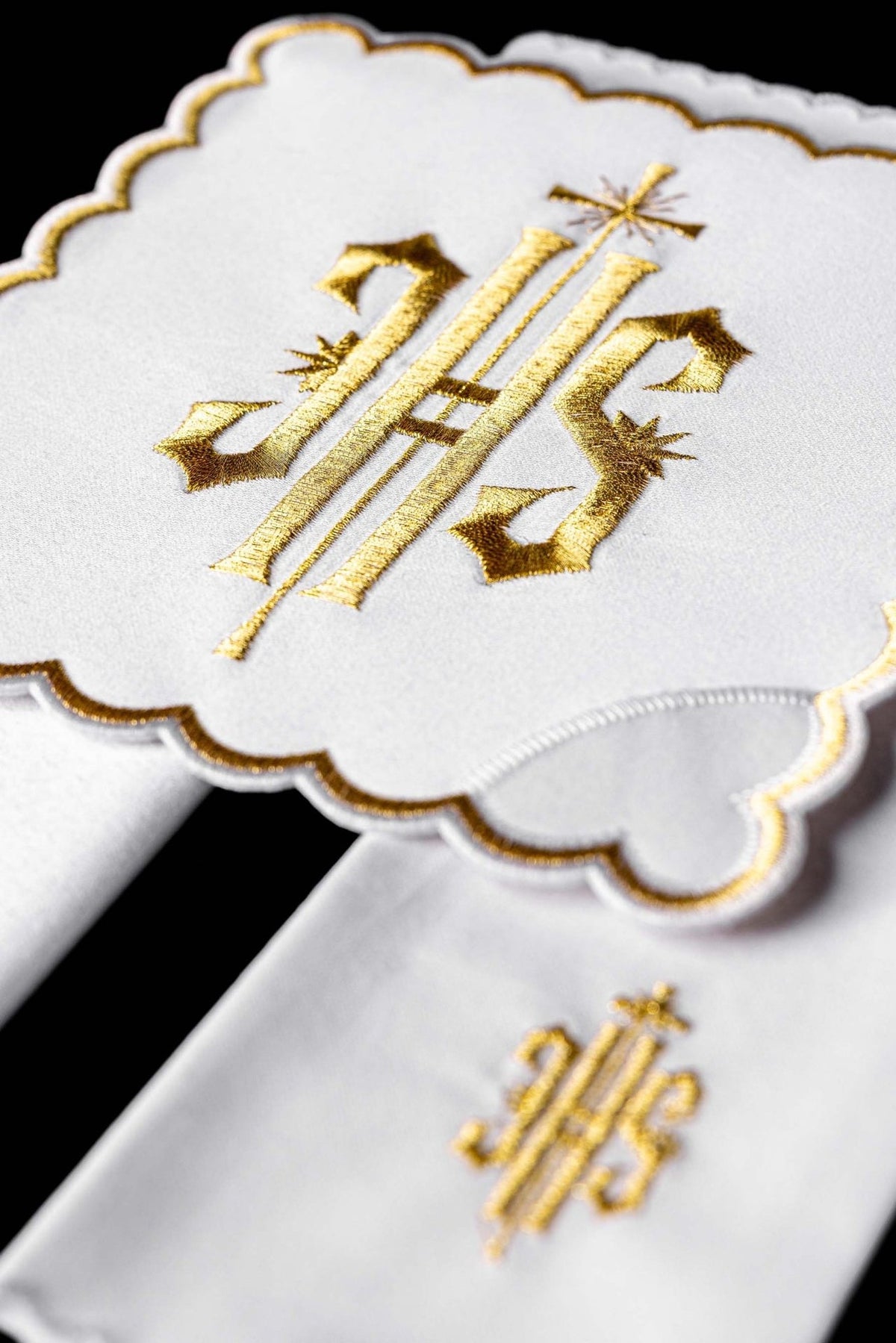 Altar linen set close-up showing gold IHS monogram embroidery and scalloped gold edging