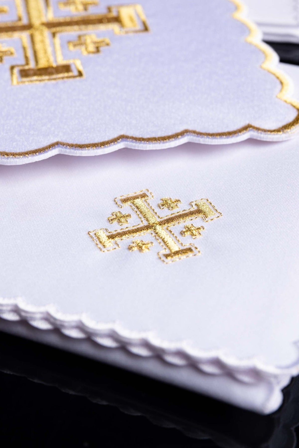 Altar linen set detail showing gold cross embroidery on white fabric and scalloped edging