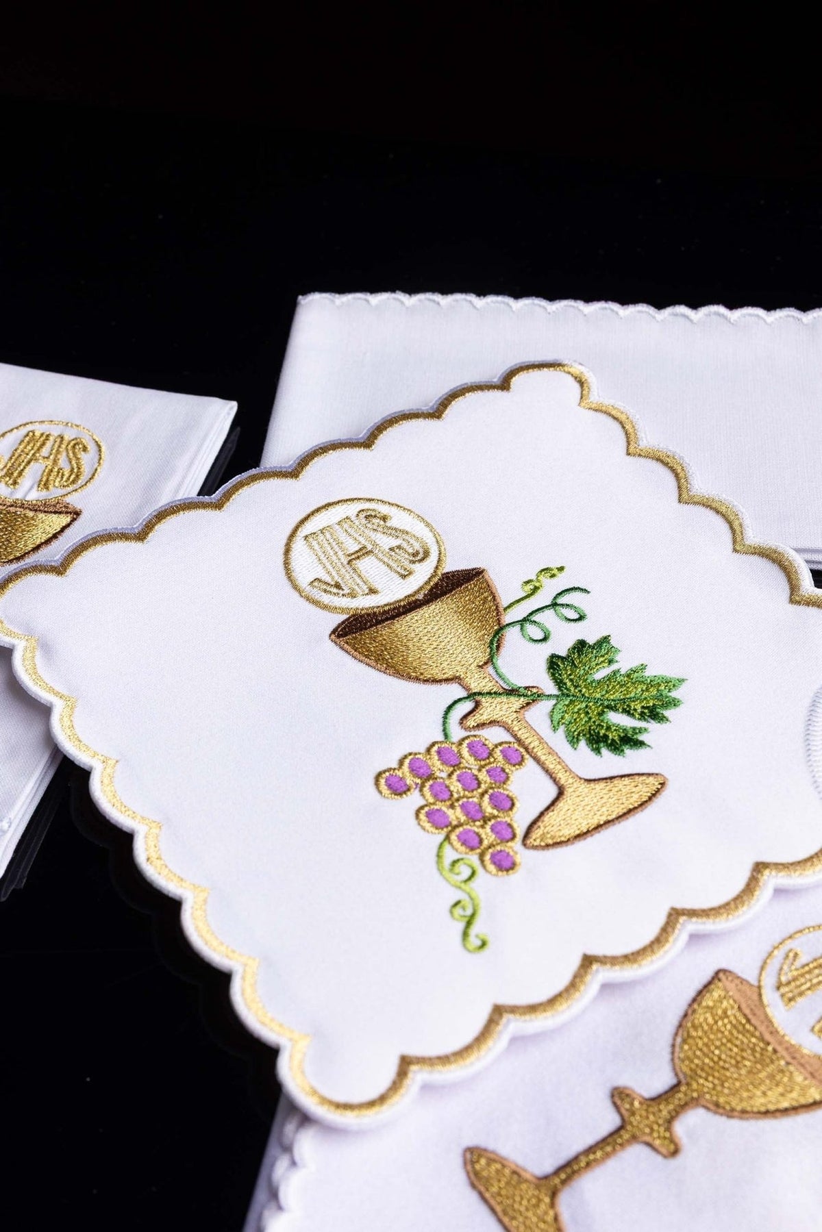 Altar linen set close-up showing embroidered gold chalice, grapes, vine and green leaves