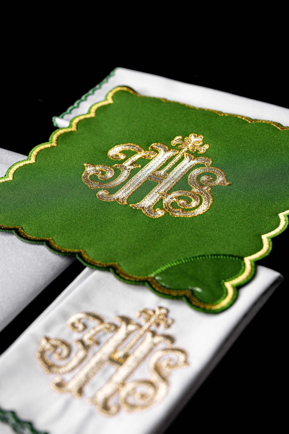 Green chalice pall close-up showing gold IHS embroidery and scalloped edge