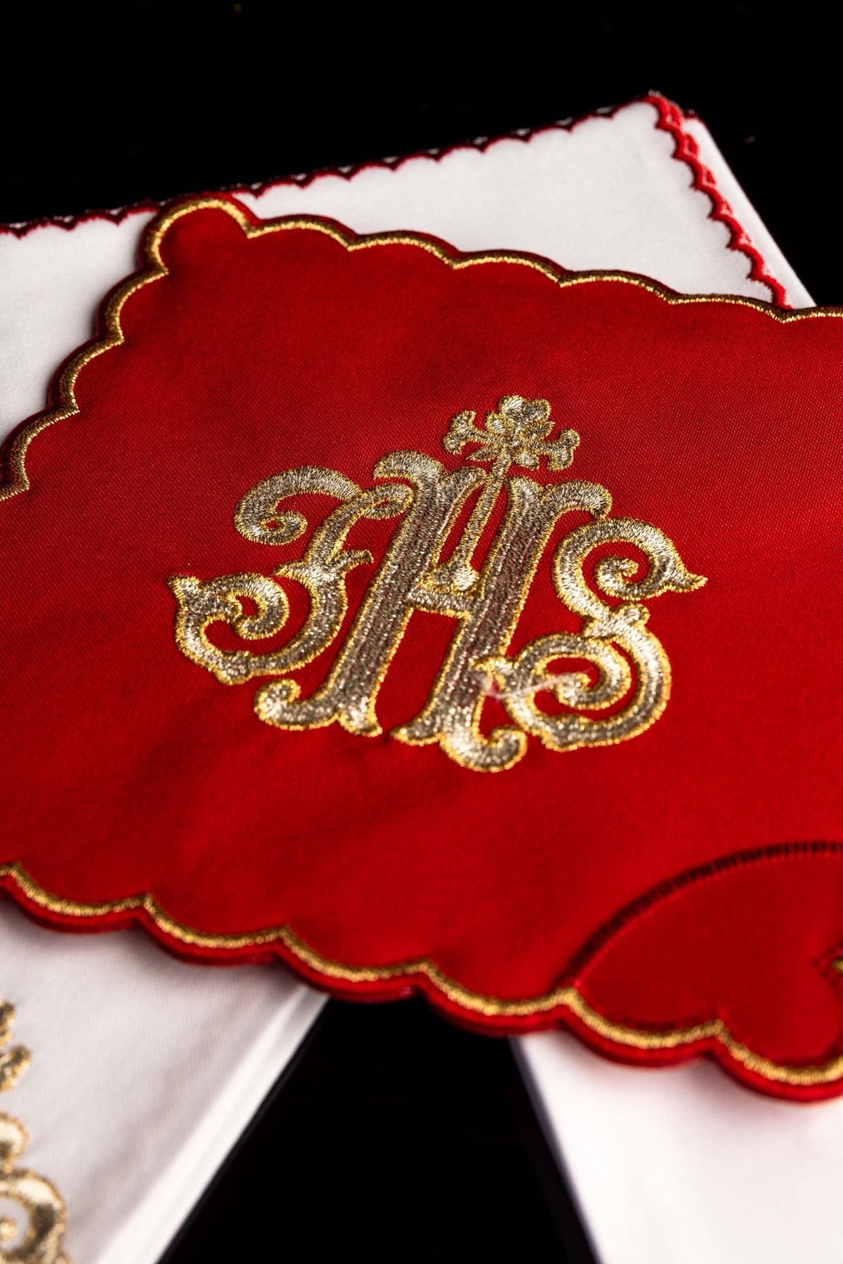 Red altar linen set close-up showing gold embroidered IHS and scalloped gold edging