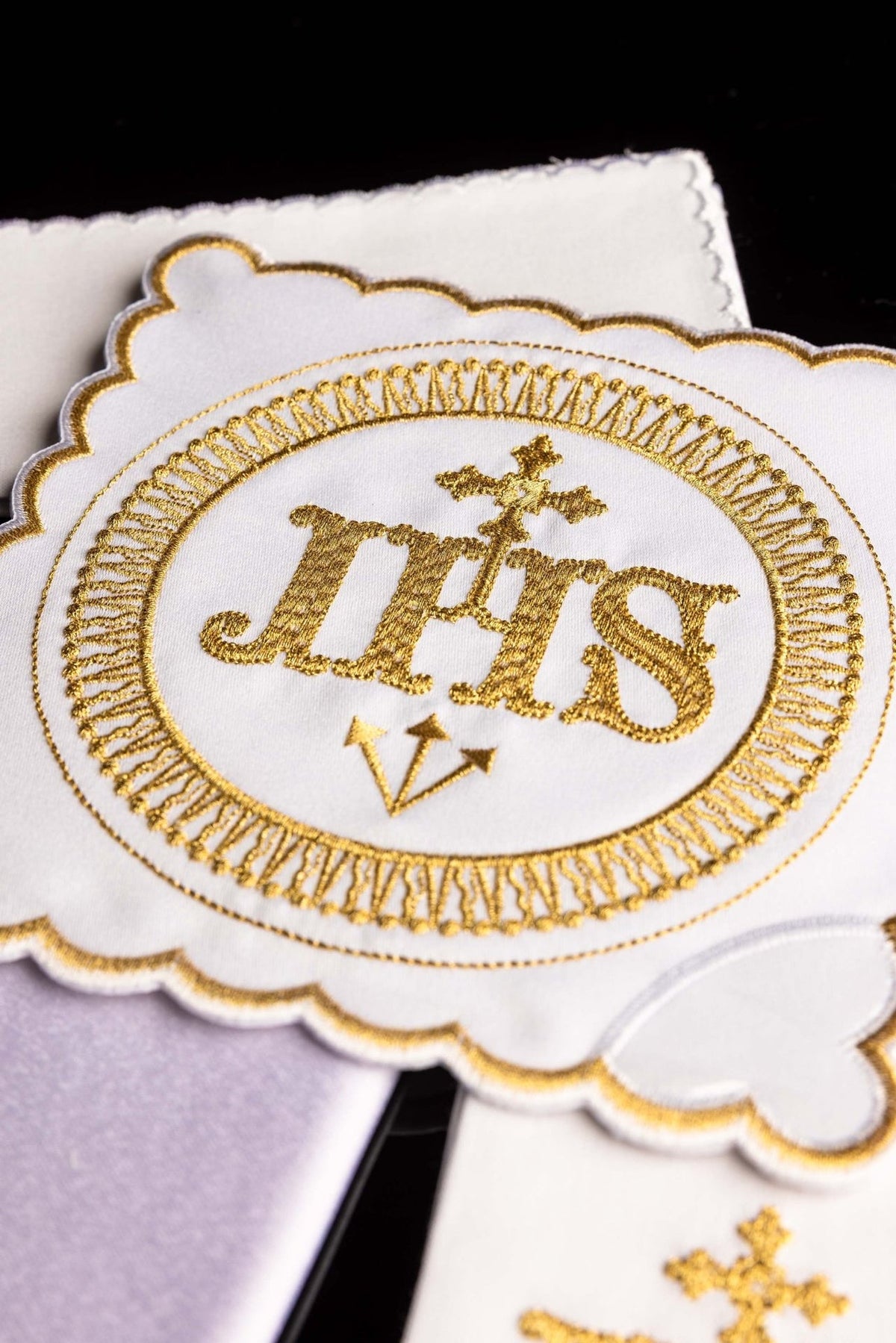 Altar linen set close-up showing gold IHS embroidery and circular decorative border