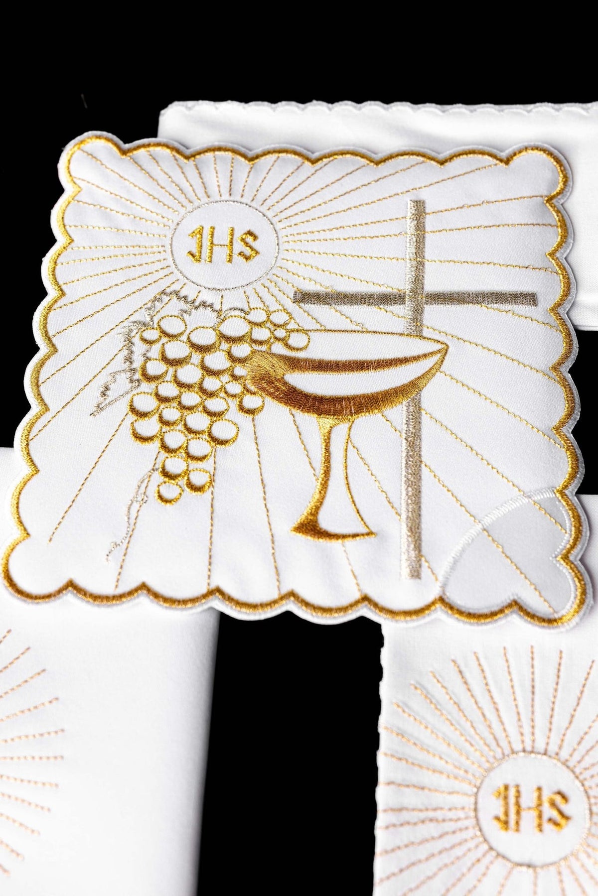 Altar linen set close-up showing embroidered gold chalice, grapes and cross