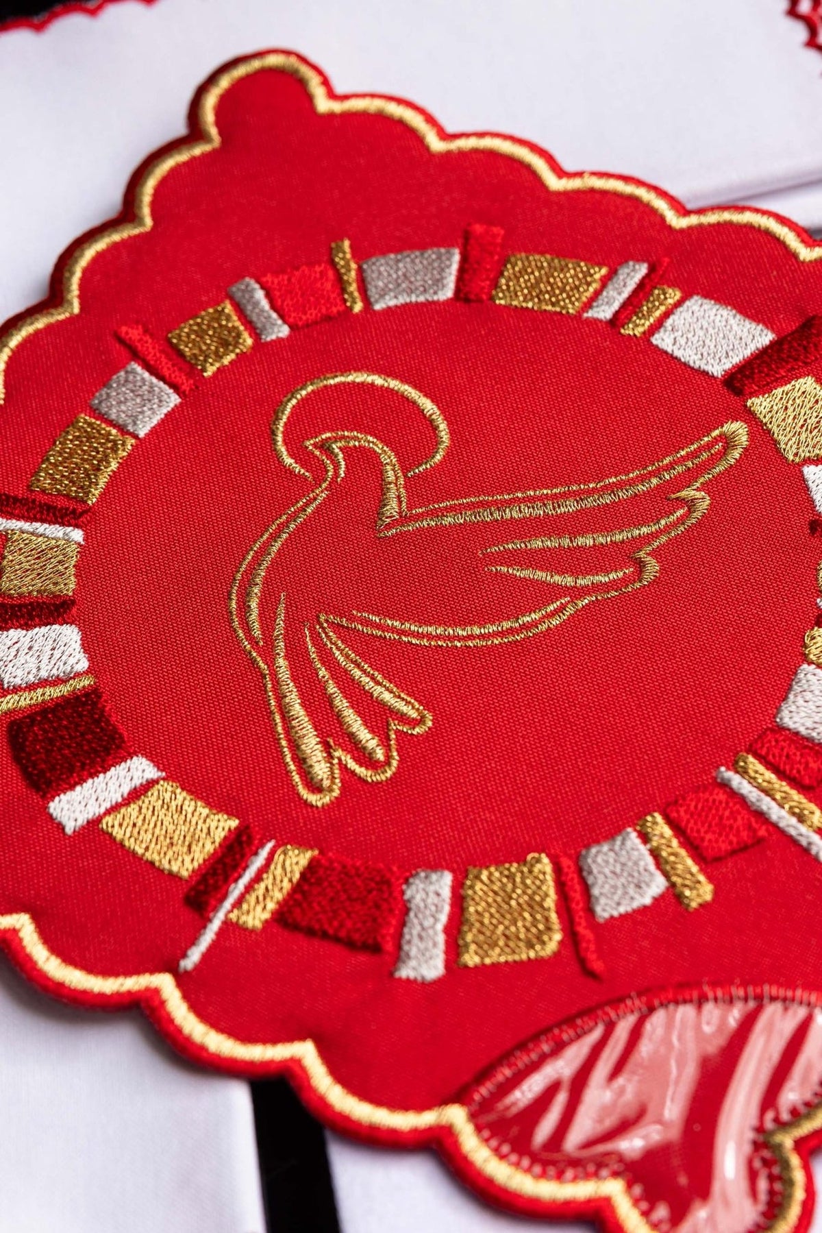 Altar linen set close-up showing red embroidered chalice pall with gold Holy Spirit and mandala motifs