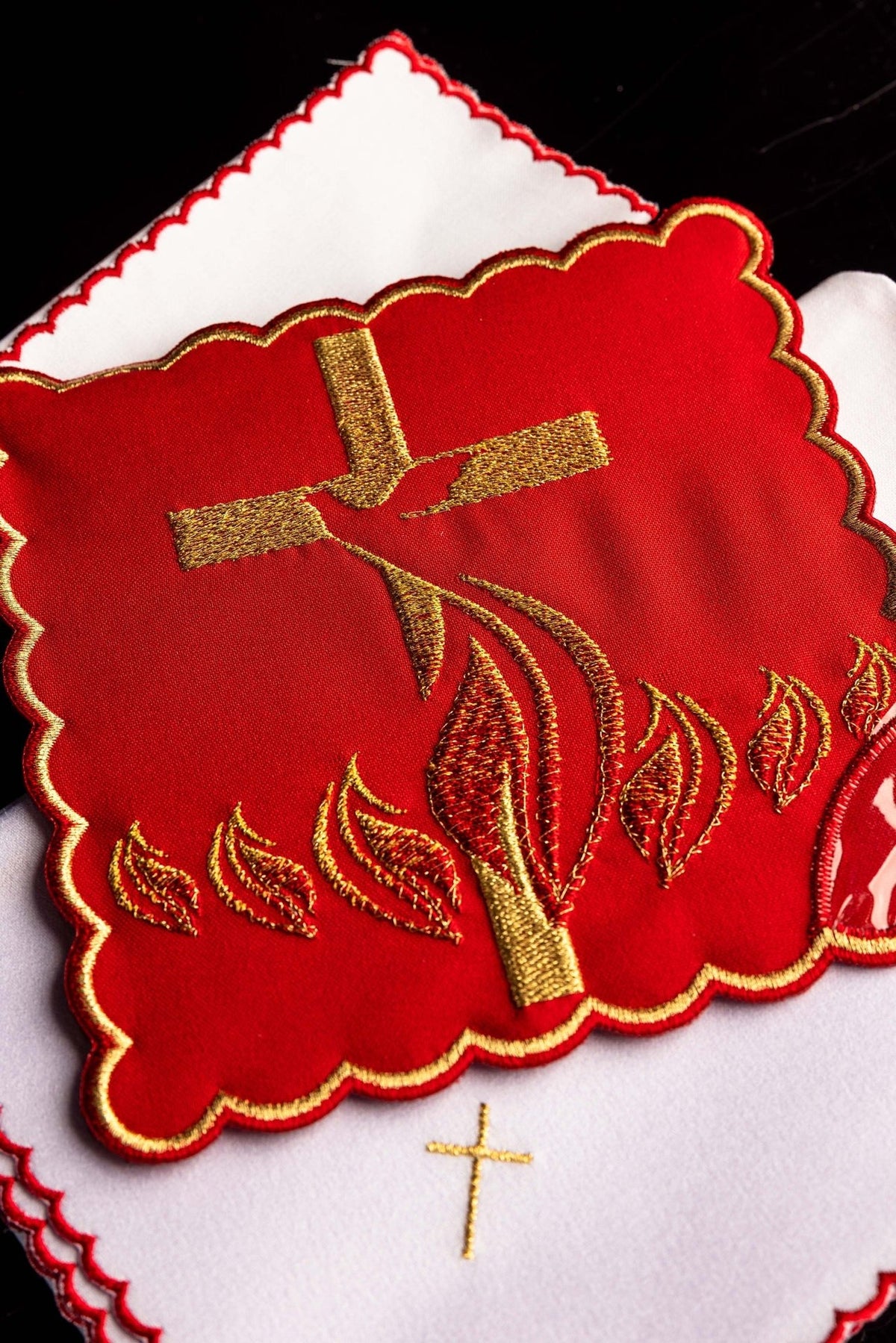 Altar linen set close-up showing red centerpiece with gold Holy Spirit embroidery