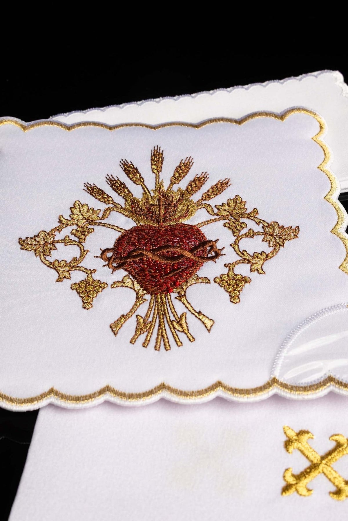 Altar linen set close-up showing embroidered Sacred Heart of Jesus in red, brown and gold